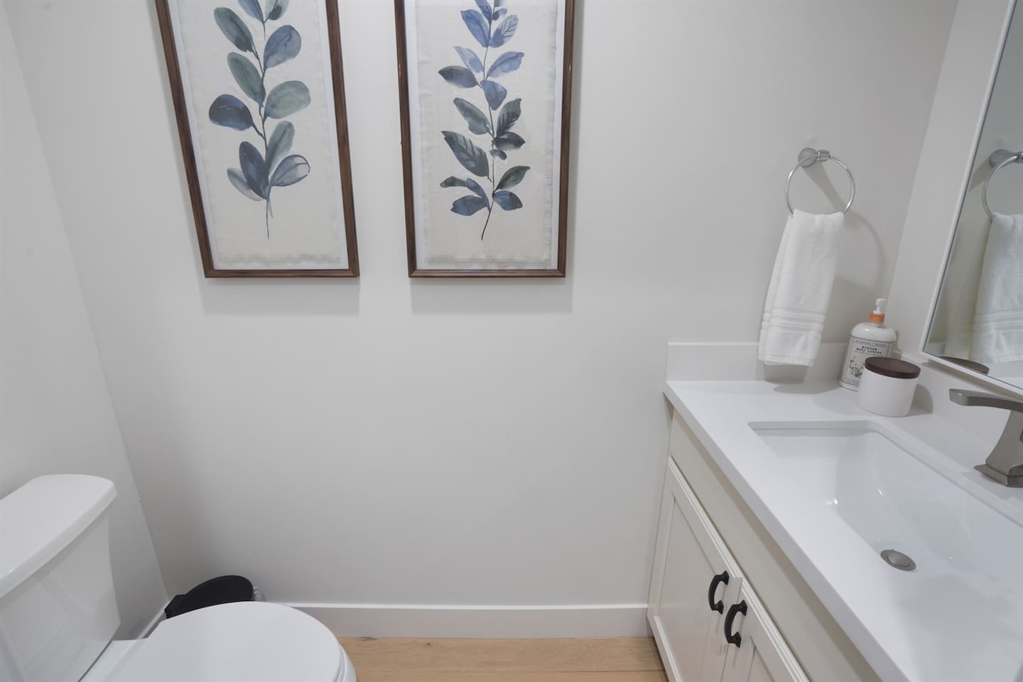 This half bath features a sleek vanity and toilet, providing a stylish and functional space for guests and everyday use.