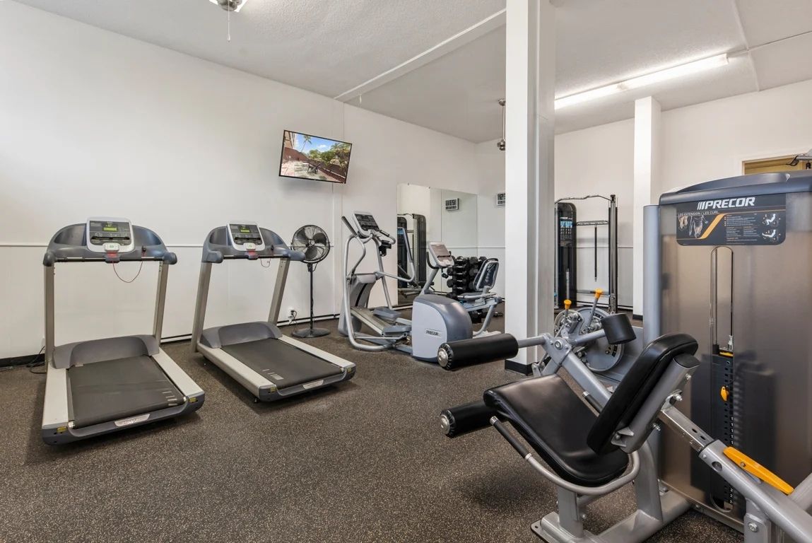 Fully equipped fitness center with treadmills and flat screens.