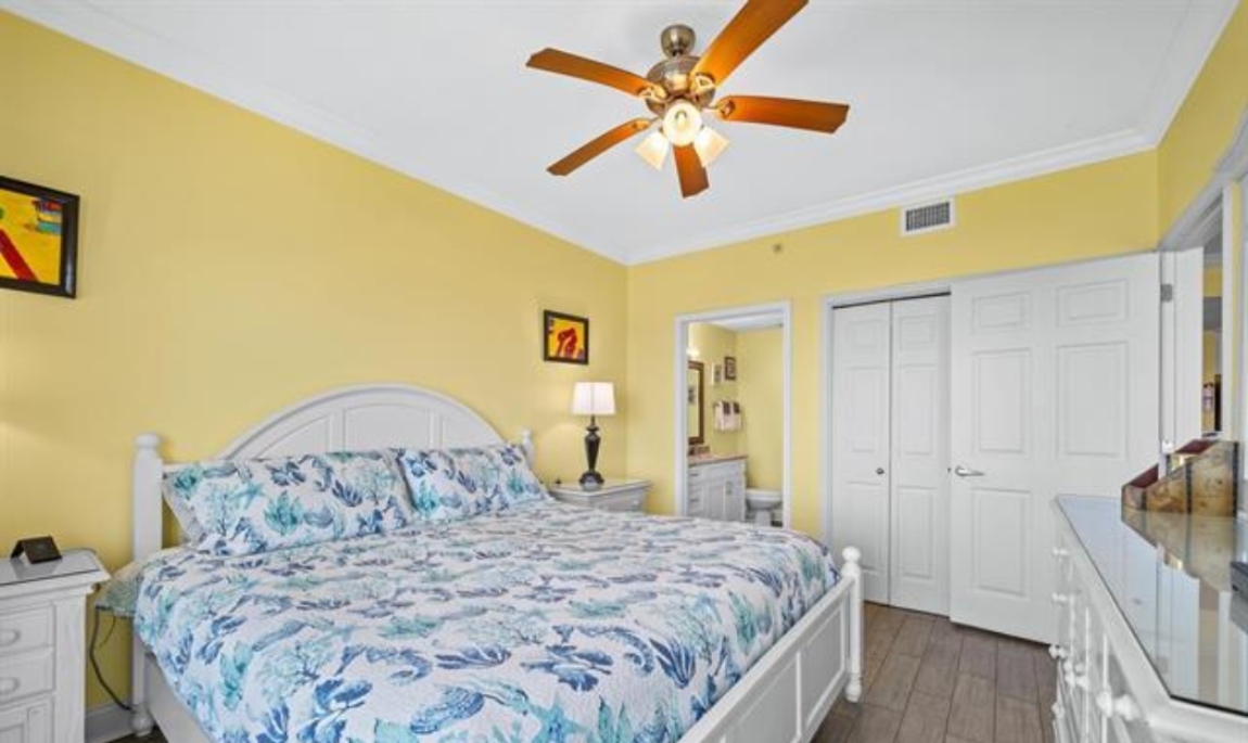 Primary Bedroom With Direct Gulf View, King Size Bed, Dresser With Mirror, 2 Nightstands, ceiling fan, double closet, 50" wall mounted Smart TV, Direct Balcony Access & Ensuite Full Bathroom