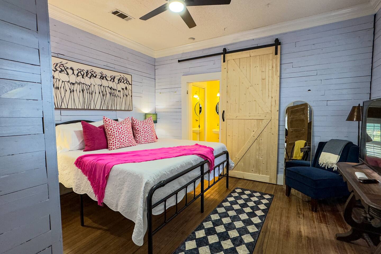 Bright, well-designed bedroom with a queen-size bed, warm lighting, and unique touches.