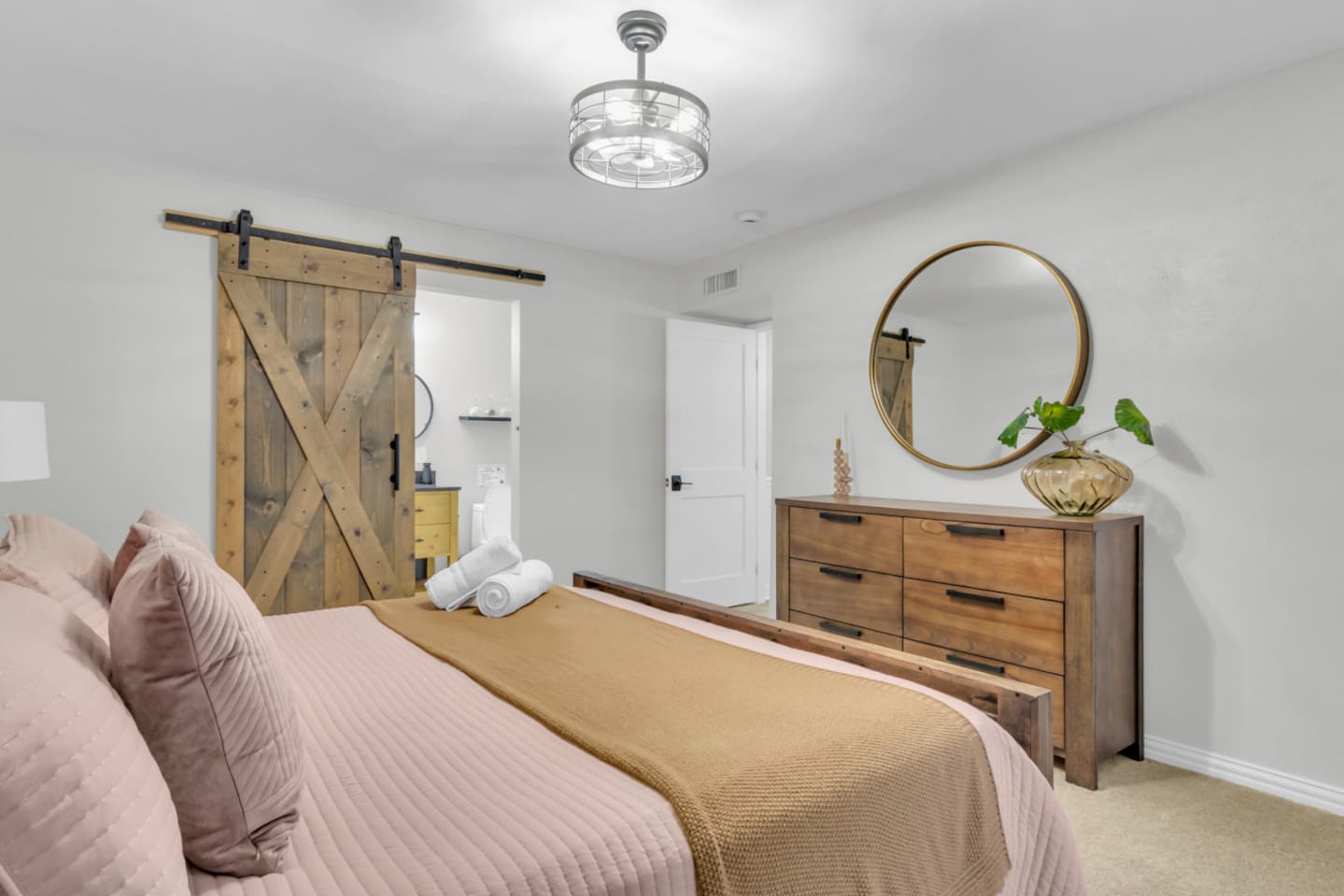 Spacious master bedroom with a stylish mirror and barn doors