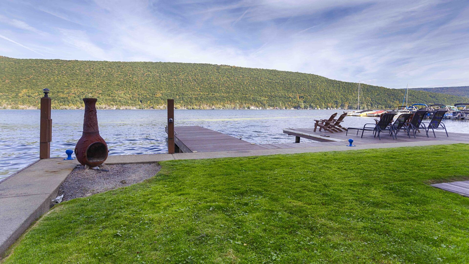 Nestled at the edge of a serene lake, this charming dock features a row of inviting, comfortable chairs, perfect for relaxing and enjoying the peaceful surroundings. The chairs, crafted from weather-resistant materials, are designed for comfort with 