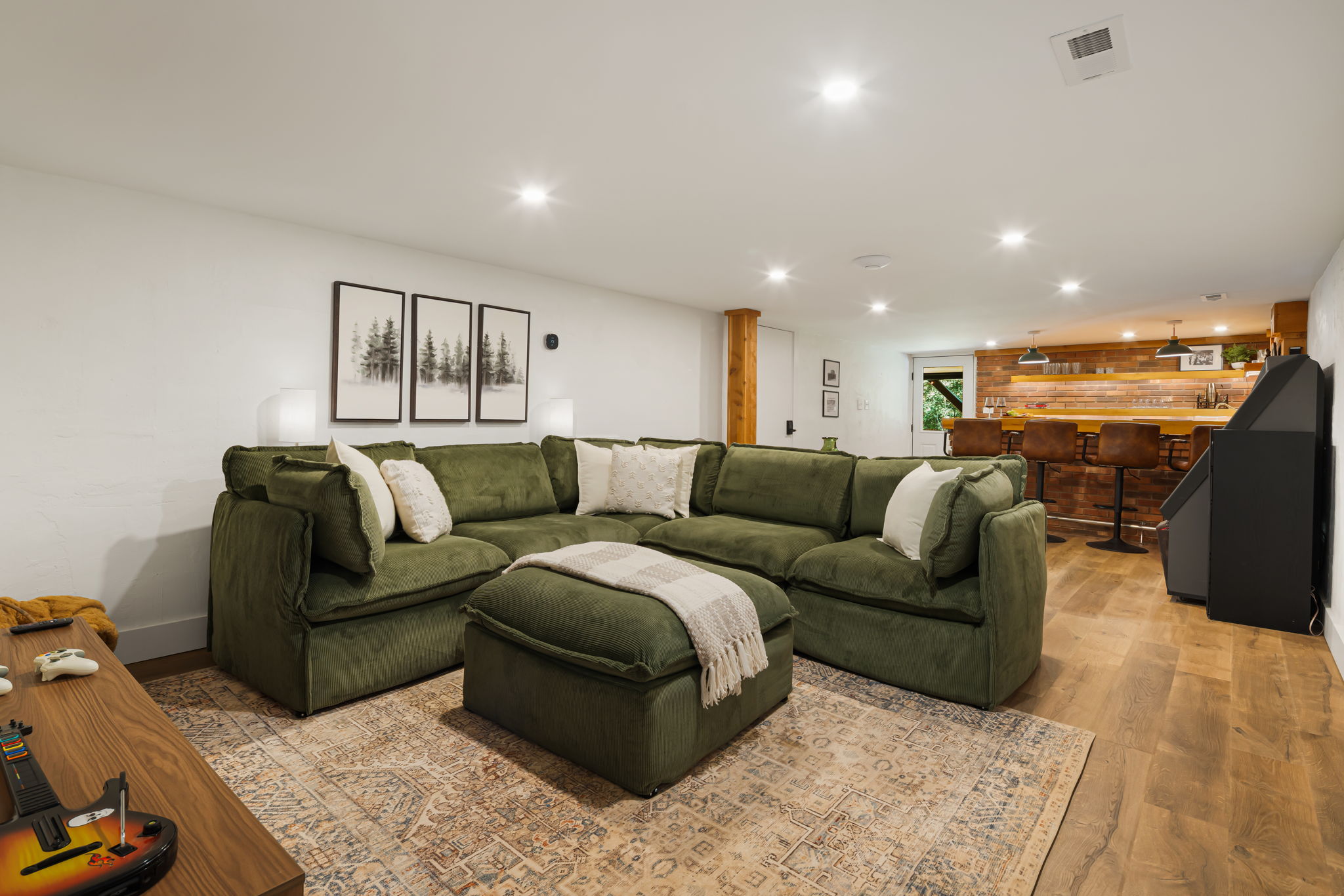A nice open floorplan of the basement offers lounging and entertaining options with a super cool, restored, vintage jukebox and a speakeasy bar setting with all the equipment needed for entertaining. 