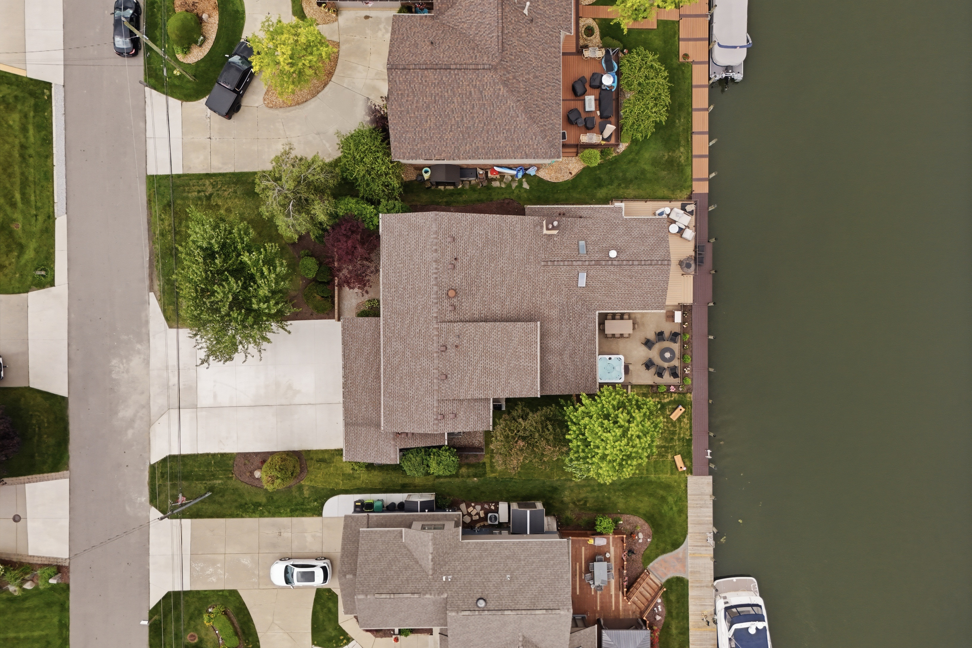 Aerial top-down view of a waterfront home with a private dock and canal access. Clean, well-maintained property offering direct water frontage in a quiet, scenic lake community.