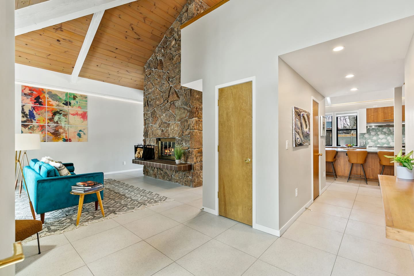 Living Room, furnished with a velvet sofa for intimate conversations, a two-sided fireplace, and easy access to the outdoor area, kitchen, and patio.