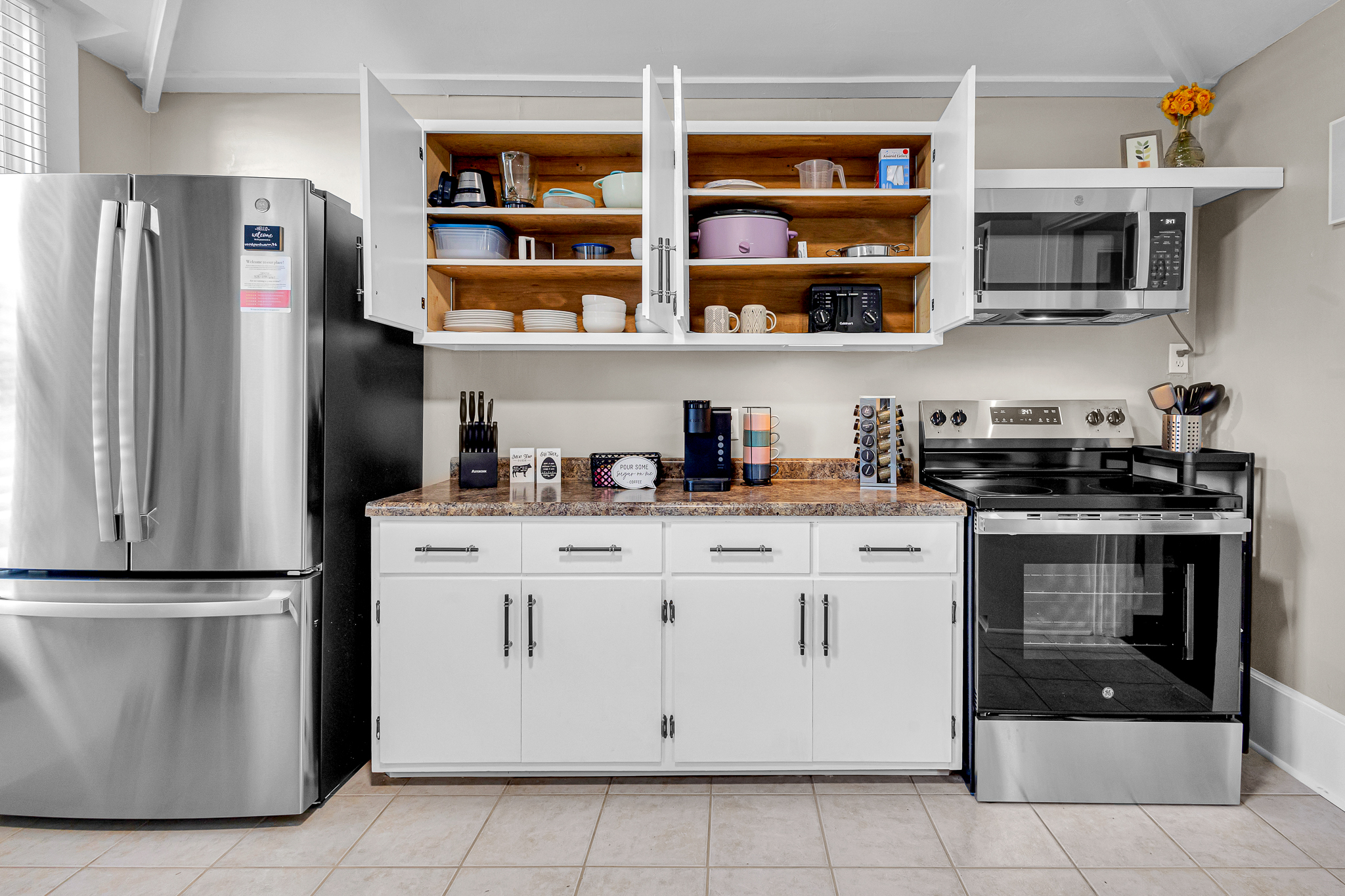 Fully stocked lower-level kitchen with fridge, freezer w/ice-maker, and electric stove/range