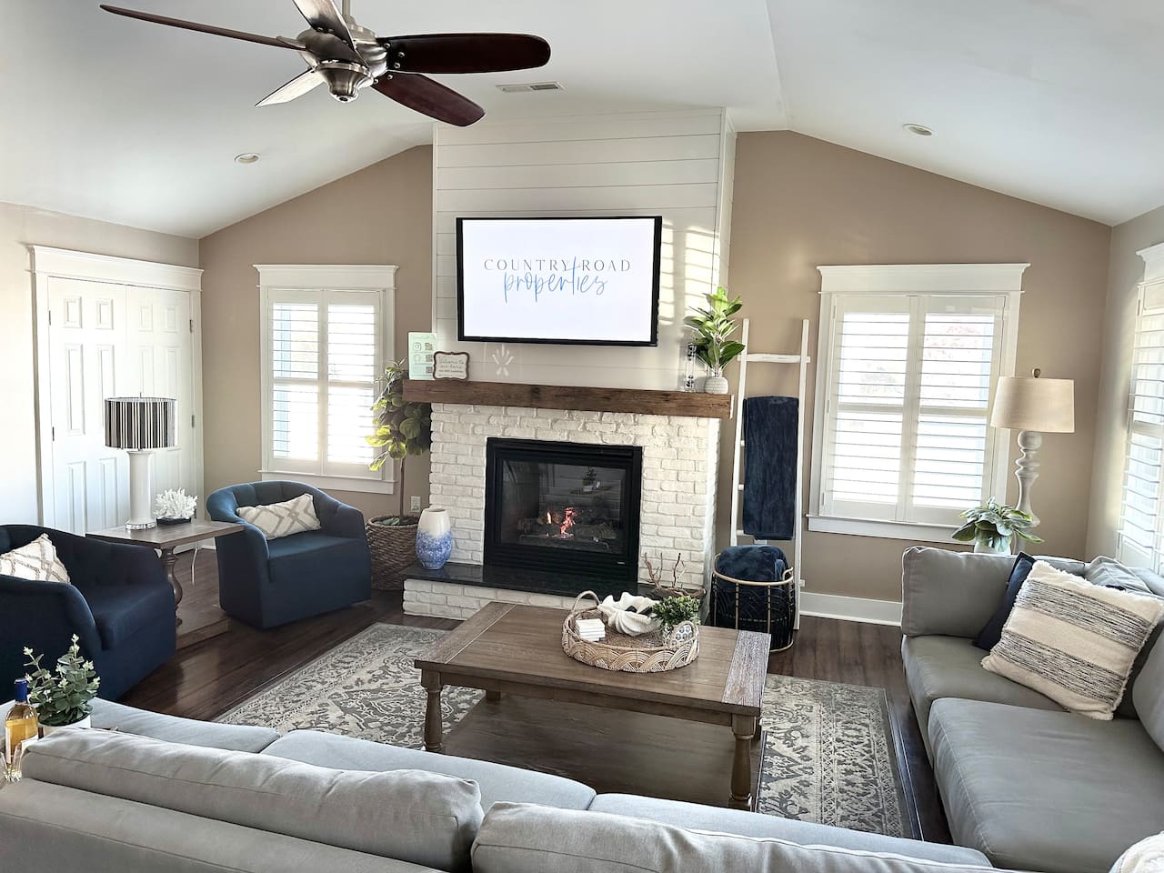Settle into this airy space with vaulted ceilings and a white brick fireplace. With a large sectional and navy armchairs, it’s a comfortable spot to stream movies or relax after a day at the shore.