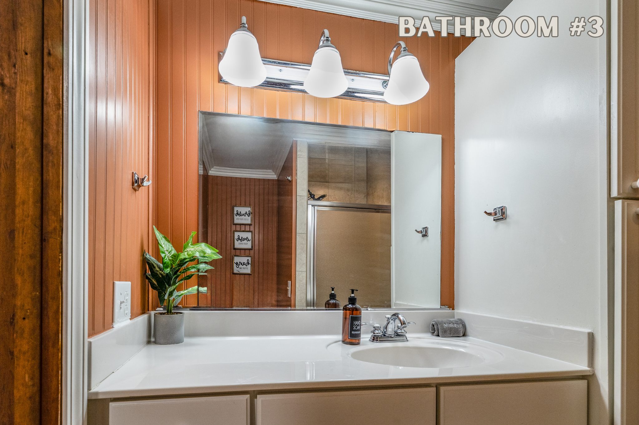 Adjacent to Bedrooms 3 and 4, Bathroom 3 is a fully equipped bathroom featuring a spacious shower, a large mirror, and modern lighting.