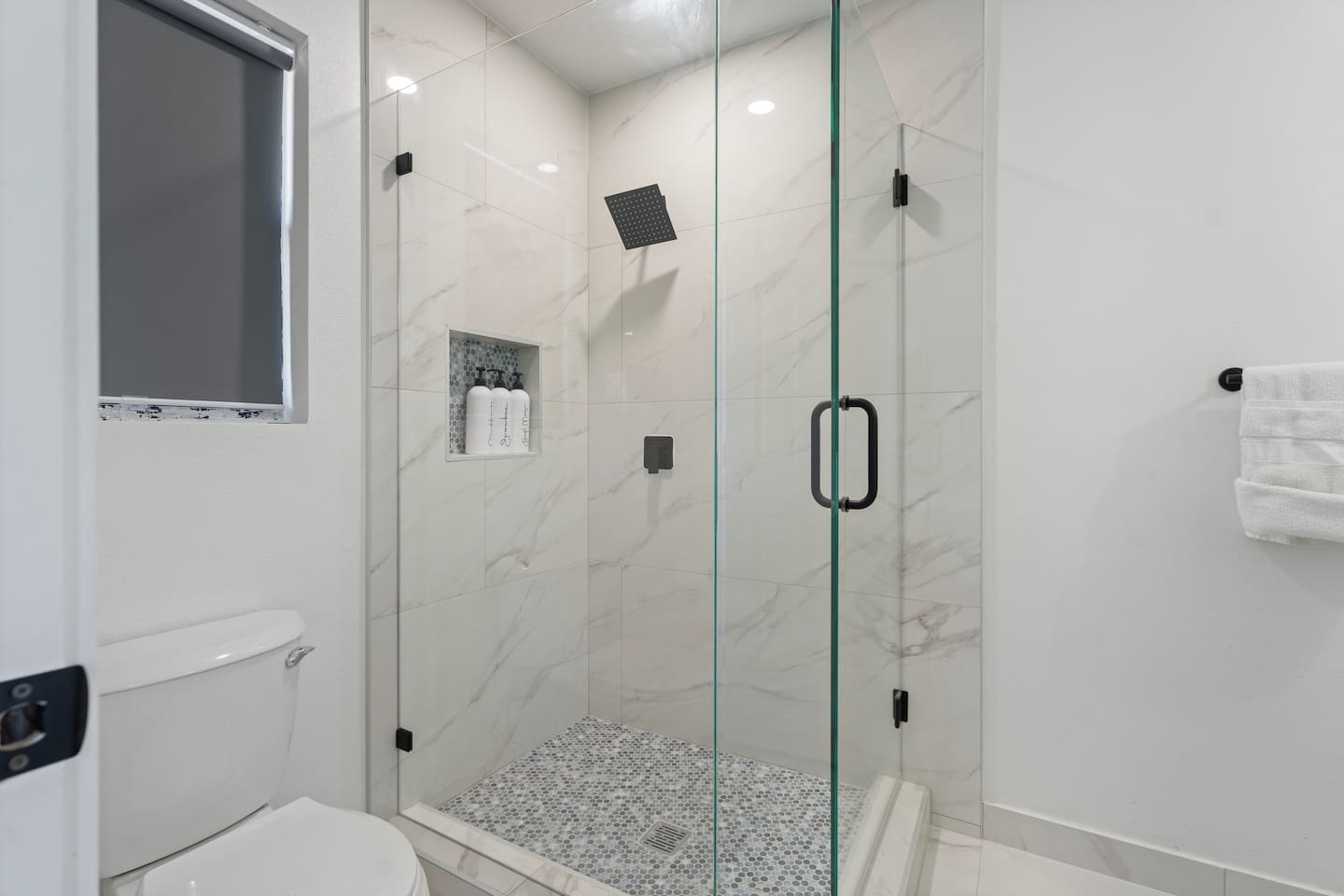 A modern walk-in shower with a rainfall shower head and premium Ginger Lily Farms bath products — a spa-style experience in your Grand Prairie stay.