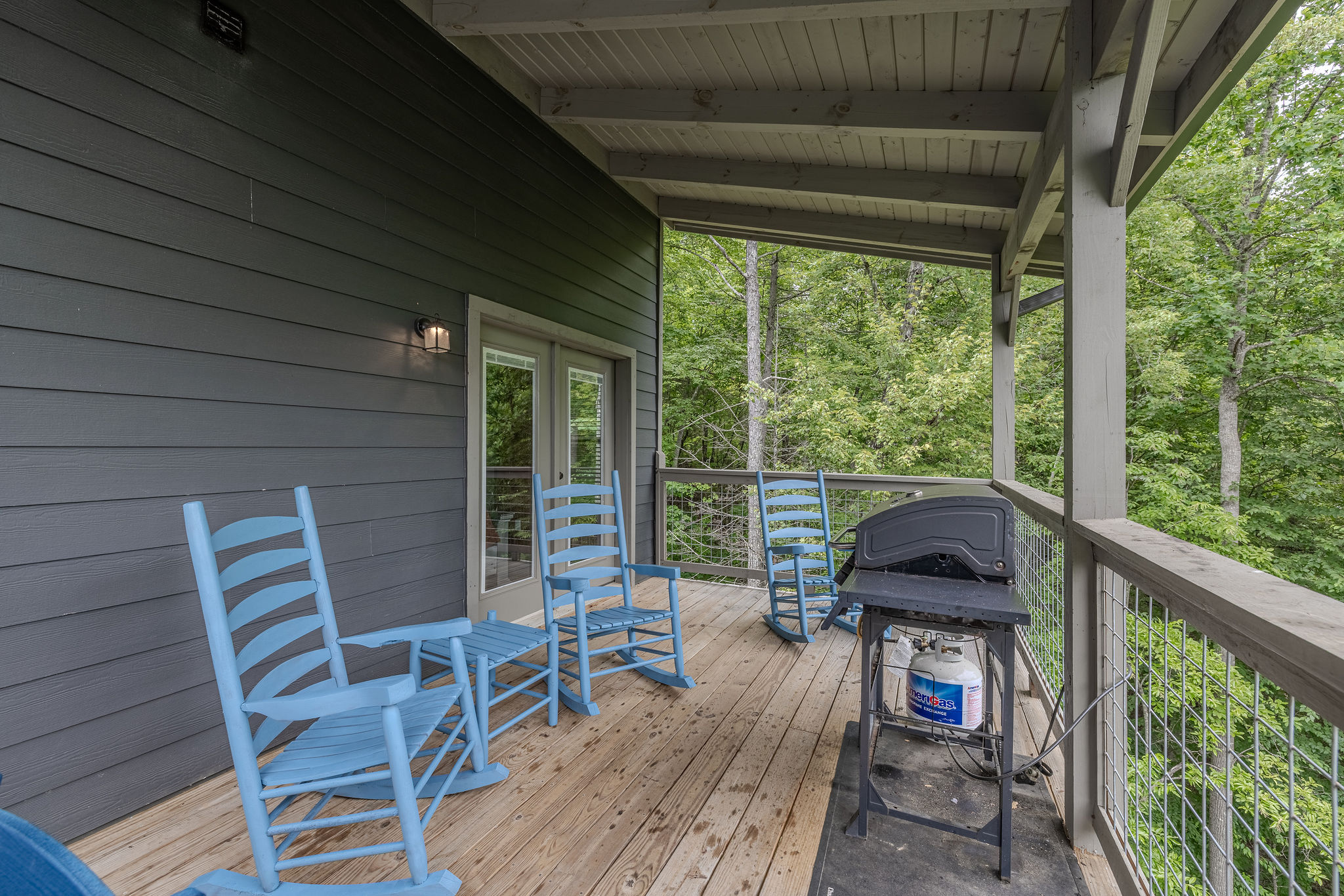 Step outside to enjoy the quiet mountain setting from the cabin’s covered deck.