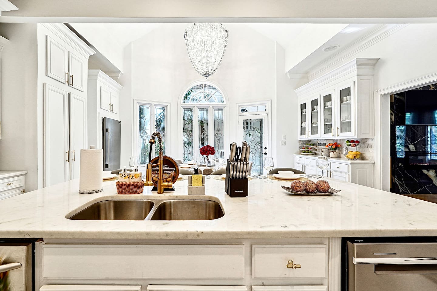 Bright and beautifully designed kitchen with white marble counters and white wood cabinetry. Fully equipped and ideal for cooking, gathering, and hosting with ease.