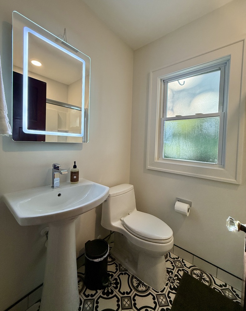 Full bathroom at the end of the hallway with an updated medicine cabinet/mirror, new elongated oval toilet, and tub/shower combo.