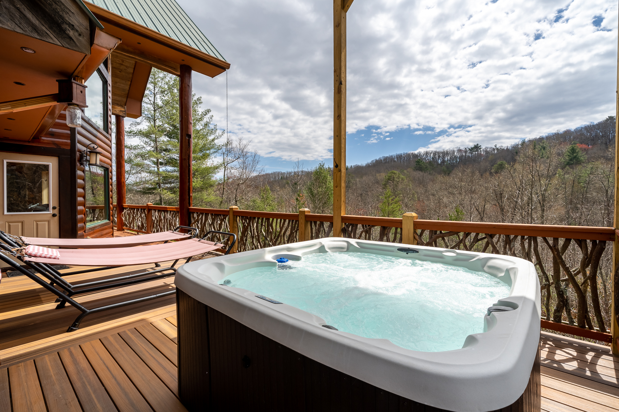 Hot tub under covered deck with beautiful mountain views.