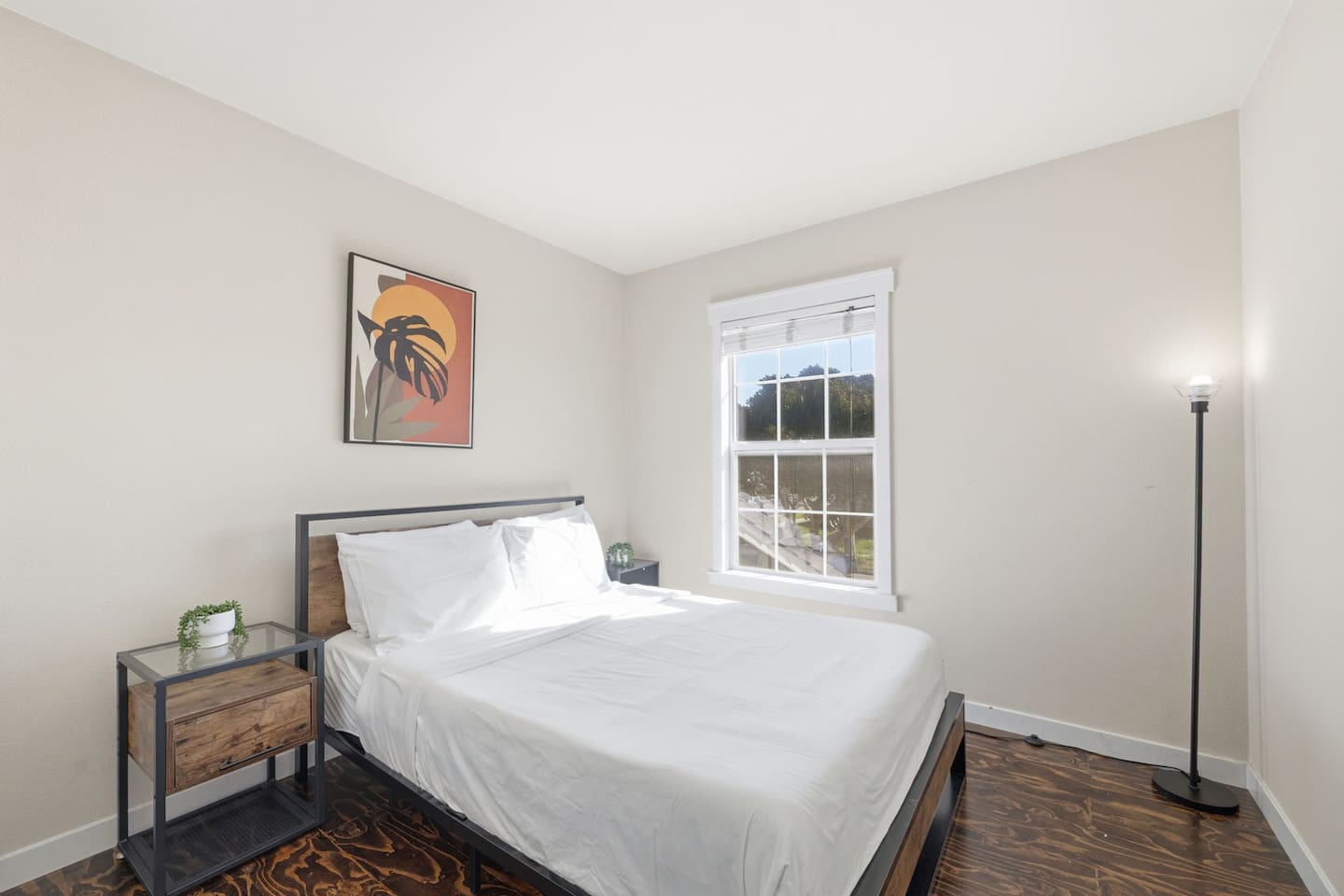 Bedroom 1 with queen bed, fresh linens, and natural light. One of four private bedrooms sleeping 10 guests total.