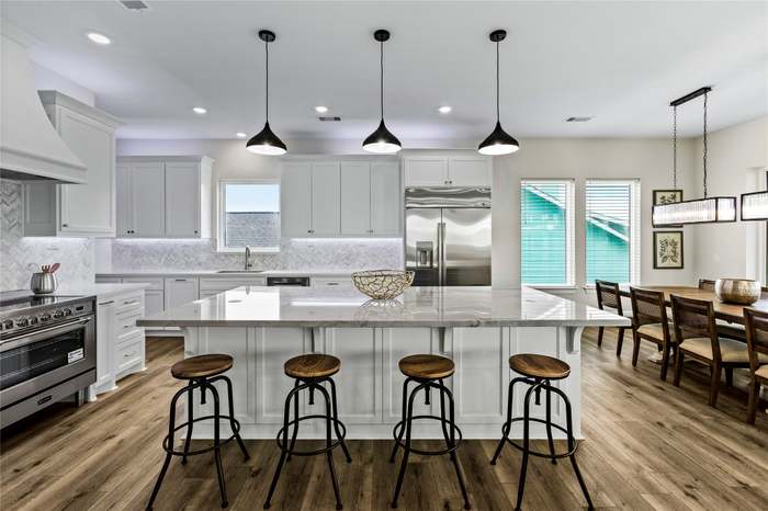Bright, modern kitchen with a large quartz island, stainless-steel appliances, and an open dining area perfect for group meals.