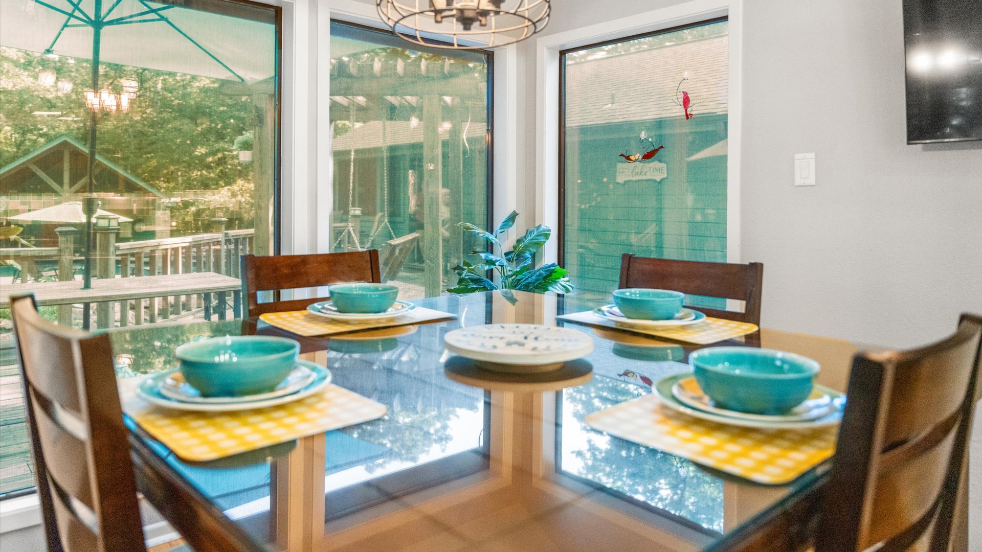 A bright and inviting dining space featuring a counter-height table and chairs, perfectly set for a cozy meal. Enjoy stunning views of the outdoor retreat while gathering with family and friends in this stylish and comfortable setting.