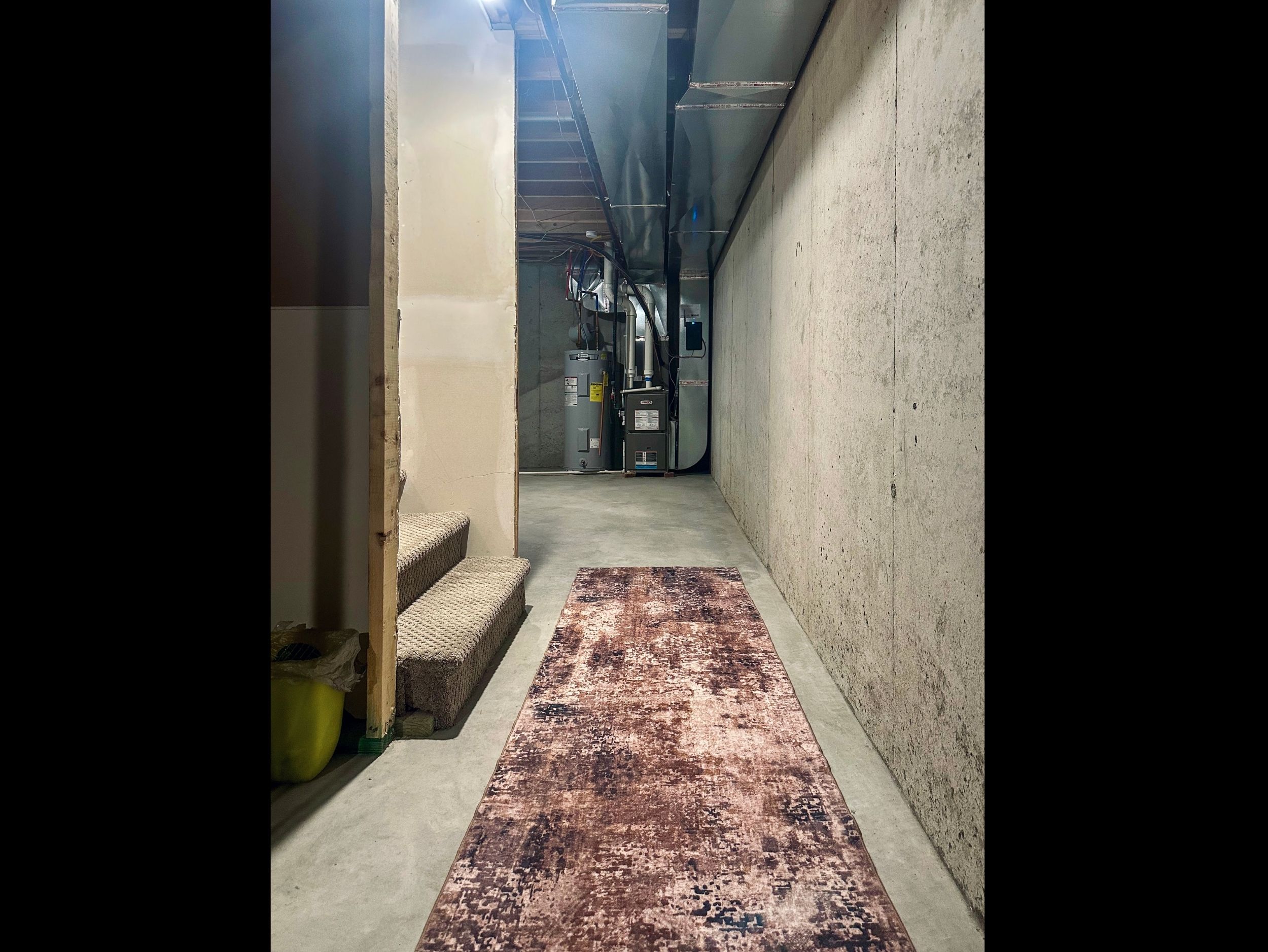 Lower-level landing facing the east side, offering clean, open space with easy access to home systems while maintaining usable room for organized storage.
