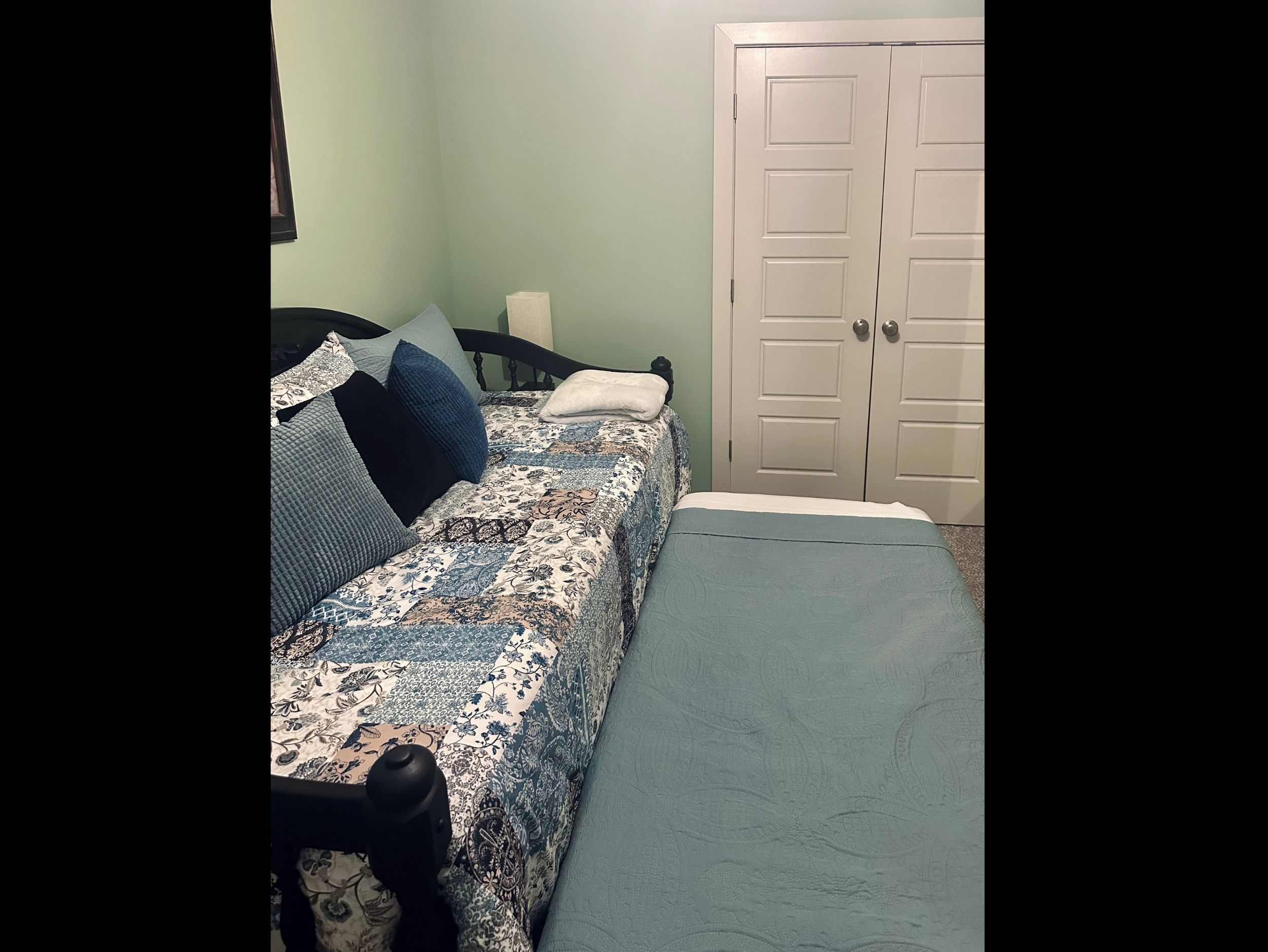 Third bedroom featuring a twin daybed with pull-out trundle that elevates to matching height, offering flexible sleeping arrangements.