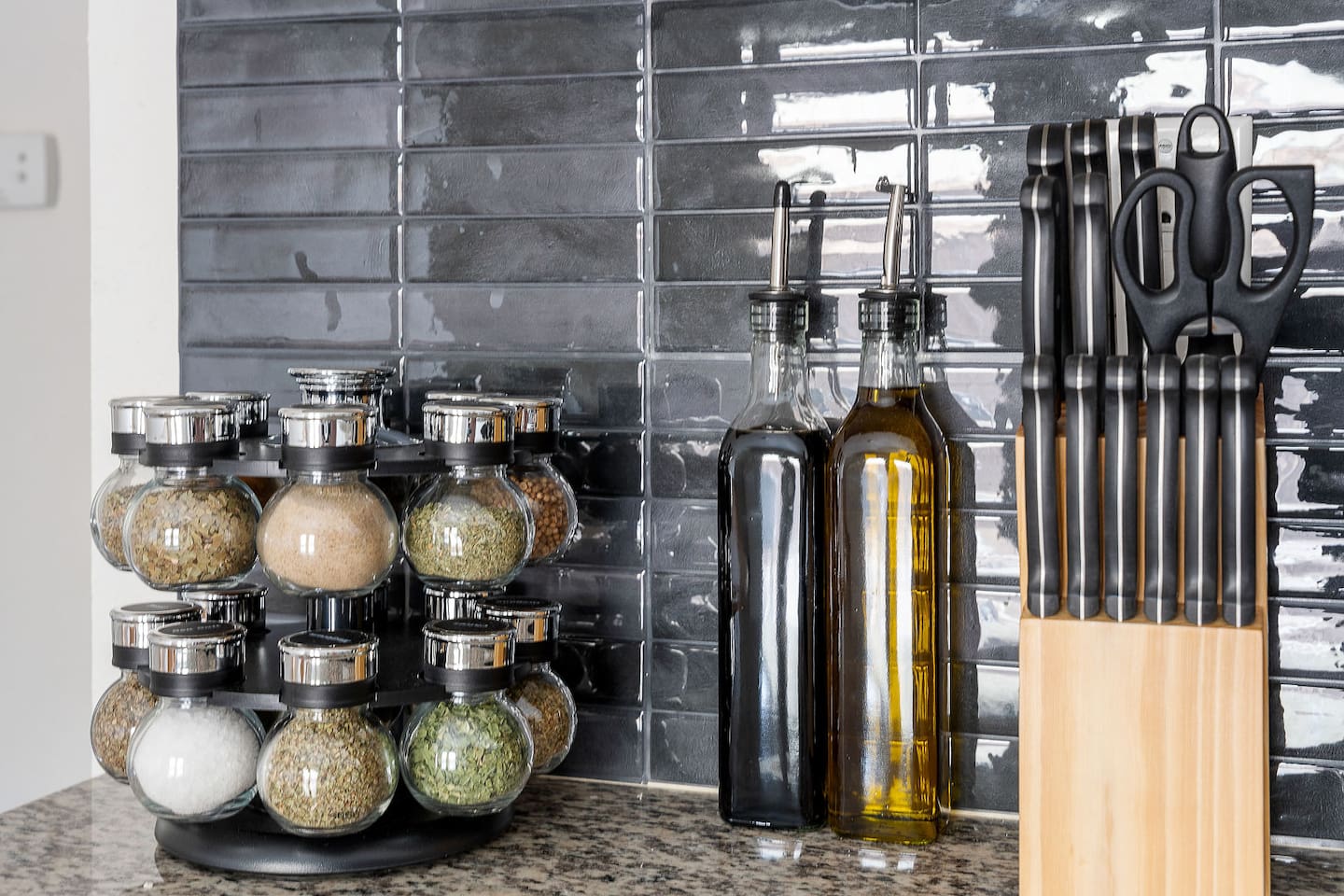 Season your meals to perfection with a well-stocked spice rack and essential kitchen tools. The setup is both practical and stylish.