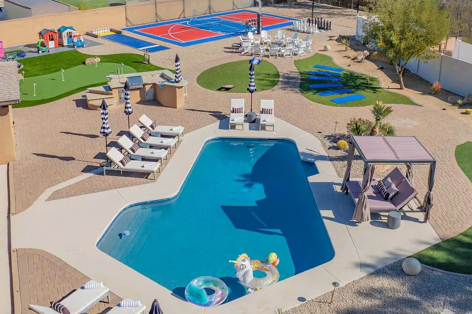 Expansive private backyard with heated pool, pickleball court, volleyball, basketball, mini golf, and a cozy firepit — perfect for large groups and family fun in Scottsdale.