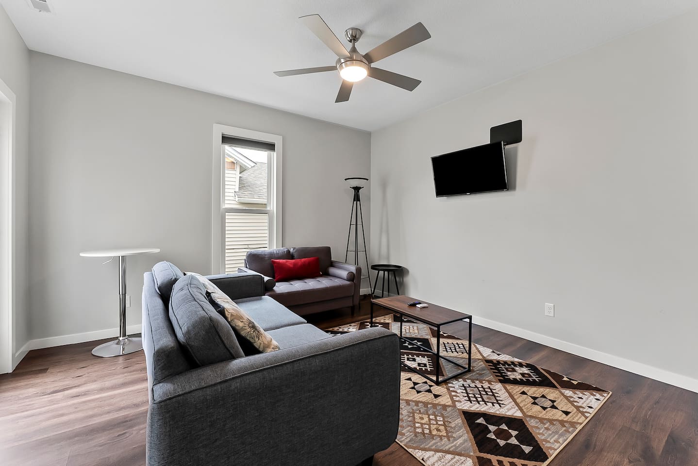 Bright and modern living space with stylish seating and a wall-mounted TV for relaxation.