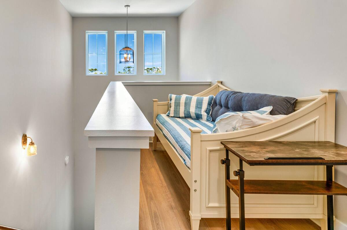 The second floor features a versatile bonus space with a twin daybed, desk, queen sleeper sofa, television, mini fridge, and coffee bar. Perfect for lounging, working remotely, or accommodating extra guests in comfort.