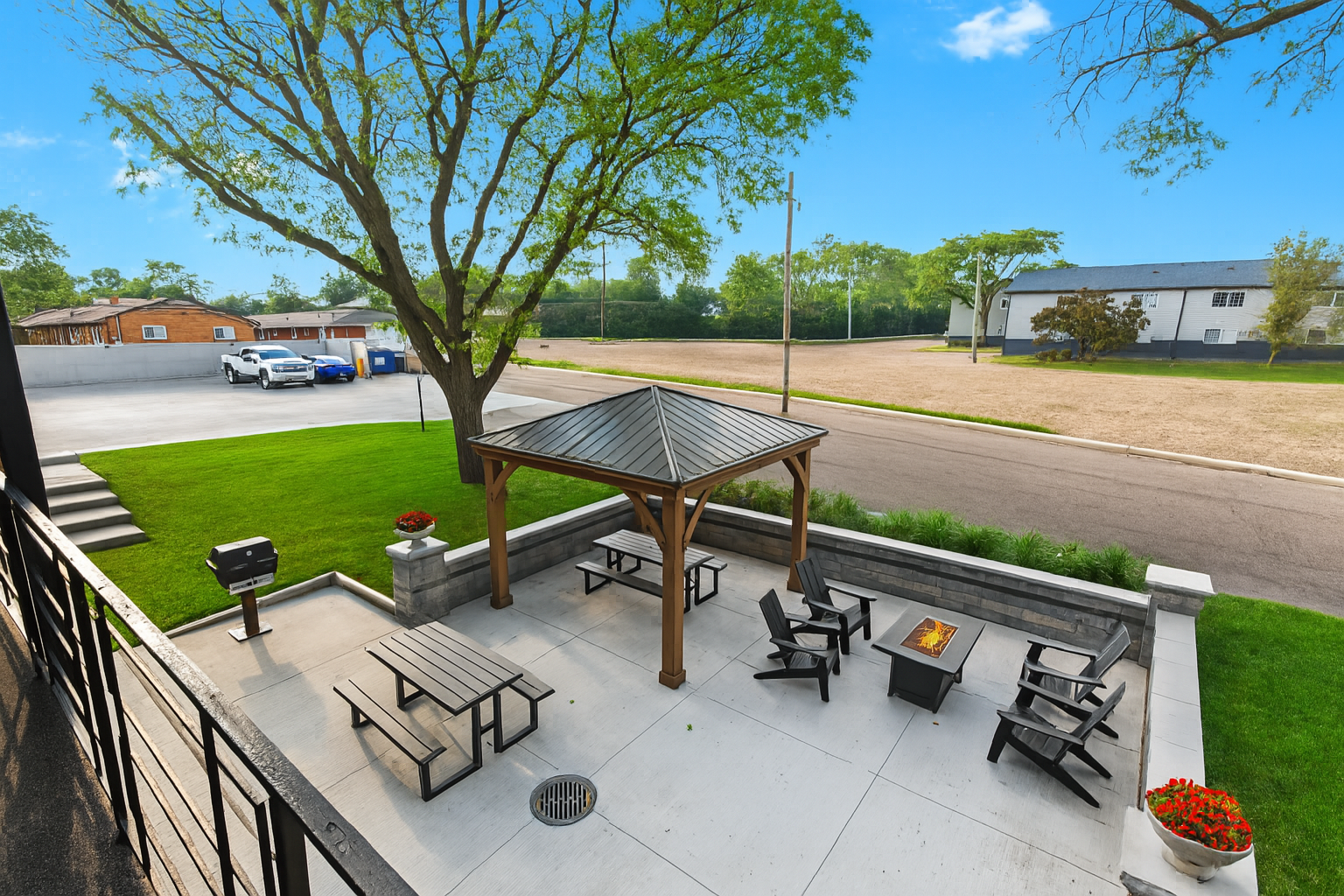 Spacious shared patio with shaded pergola and multiple seating areas for outdoor relaxation.