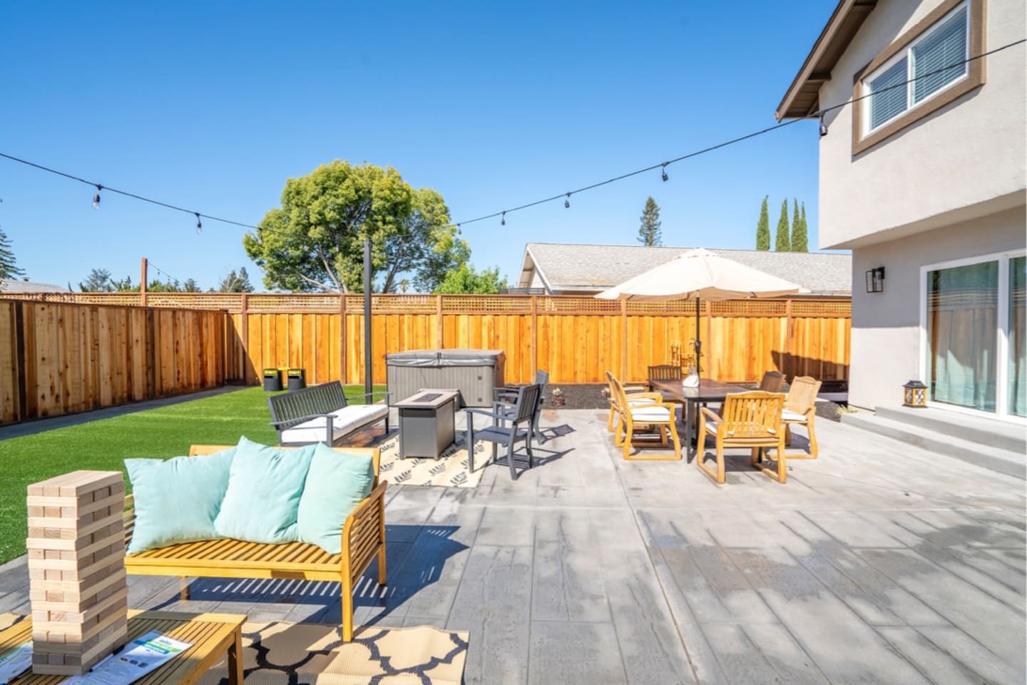 Backyard with hot tub, outdoor dining and seating with fire pit.