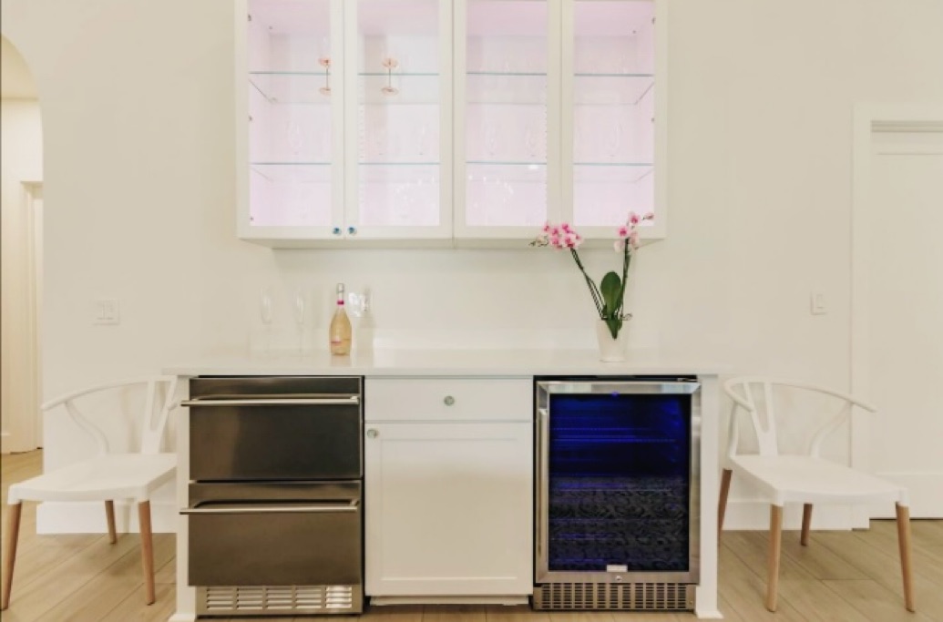 Entertaining area with a bar that includes a wine fridge and a double drawer fridge for more cool drink storage