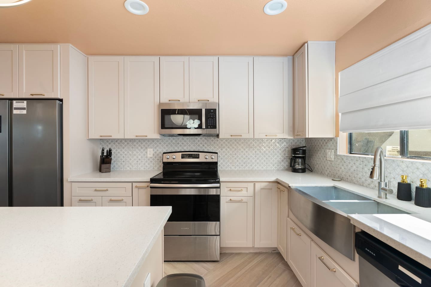 Modern kitchen with white cabinetry, stainless steel appliances, and quartz counters—fully equipped for cooking and entertaining.