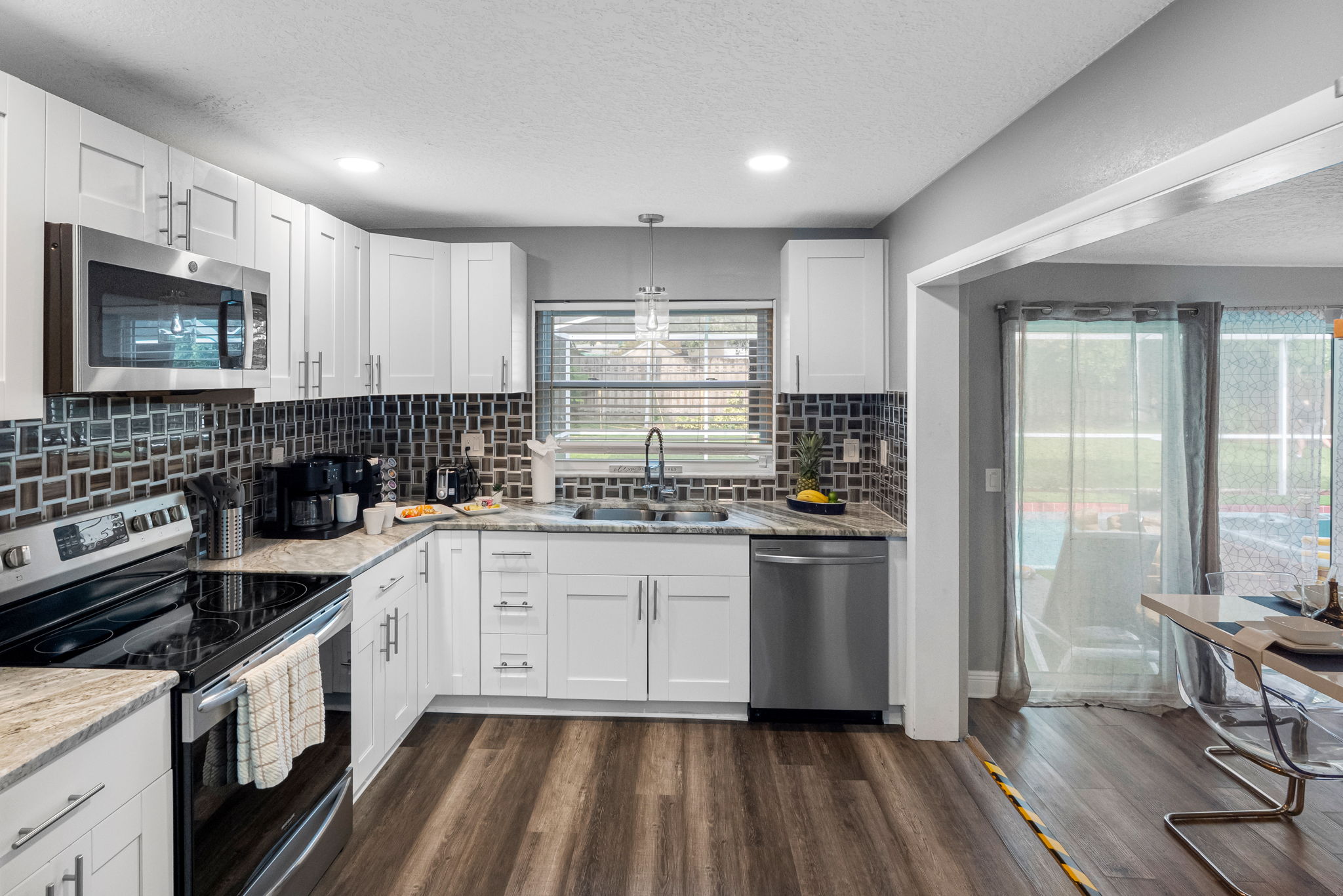 Crisp white cabinetry and warm wood-look flooring combine to create a fresh, inviting space that balances both style and practicality.
