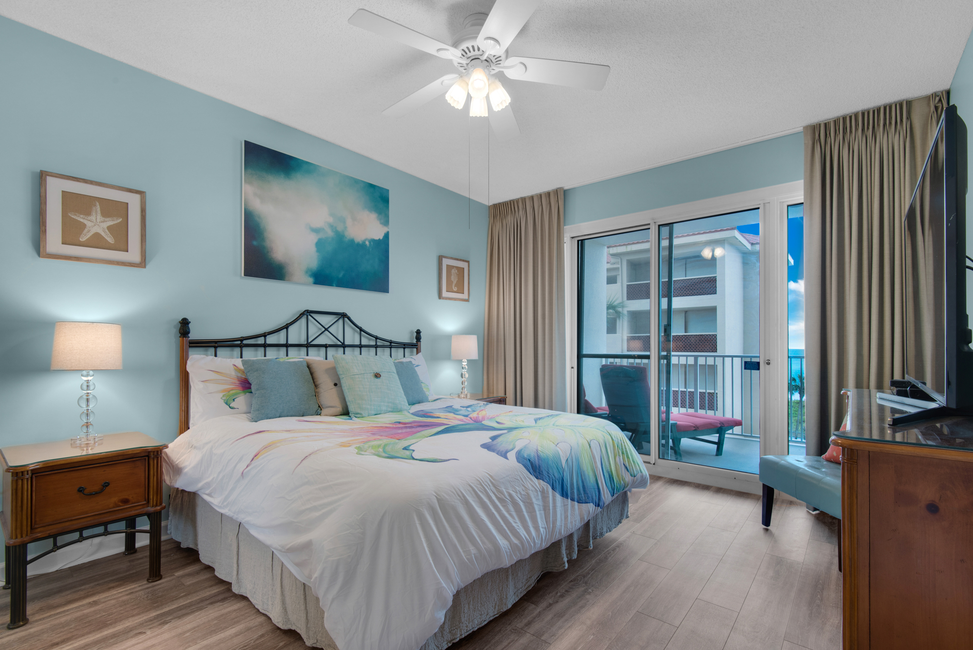 Primary king bedroom with a TV and private balcony access.