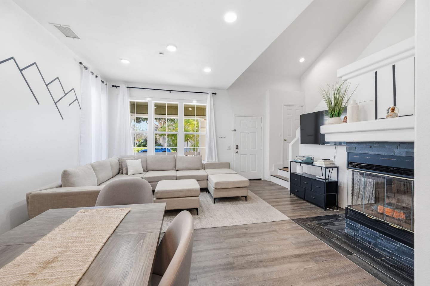 Bright living room with Smart TV, gas fireplace, and large windows. Open layout ideal for families and groups. Coastal vacation rental minutes from Oxnard beaches.