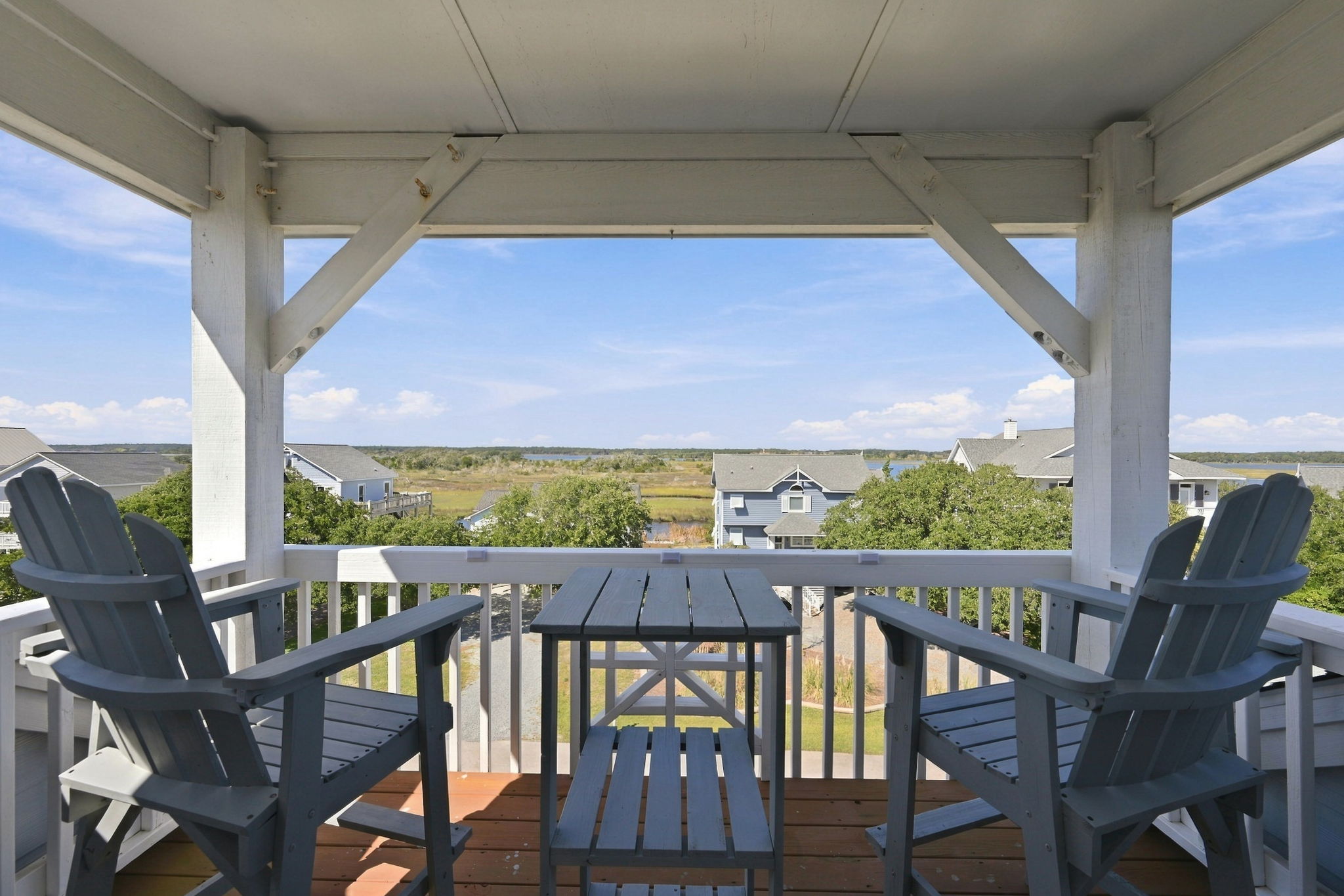 Covered balcony with Adirondack chairs, perfect for enjoying refreshing ocean breezes and elevated coastal views