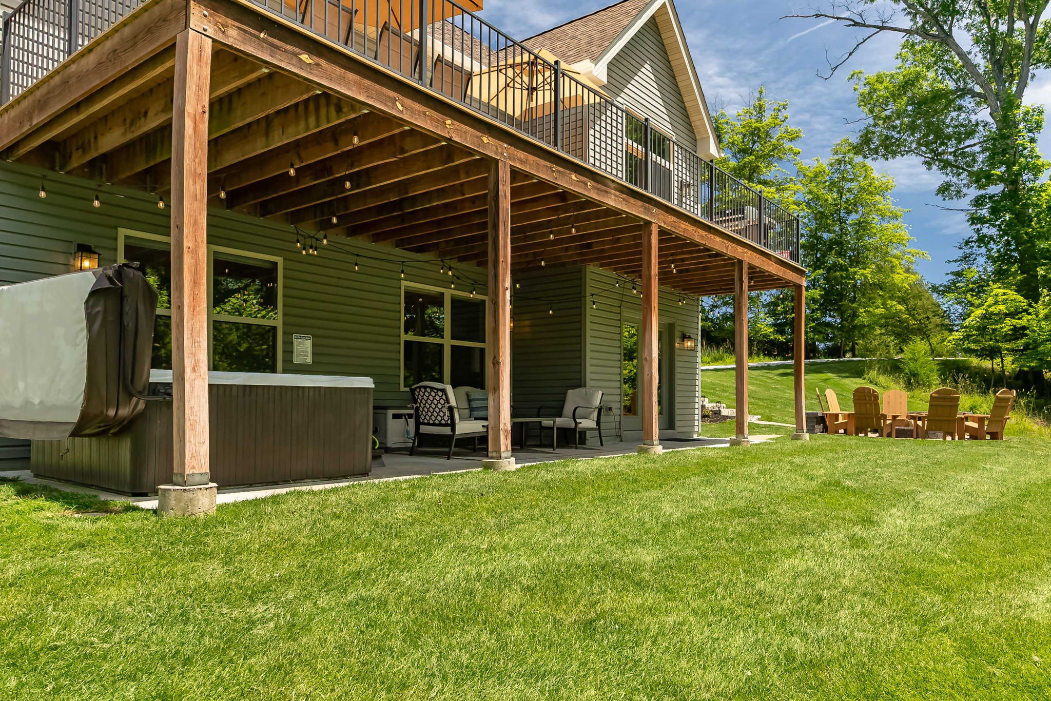 Covered outdoor living area with hot tub, dining, and lounge seating.