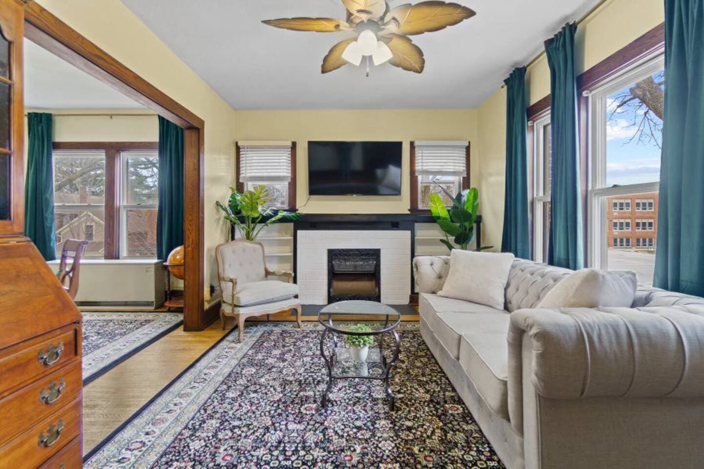 Spacious living area with a TV, wide window, and ample couch, creating a comfortable and inviting space for relaxation.