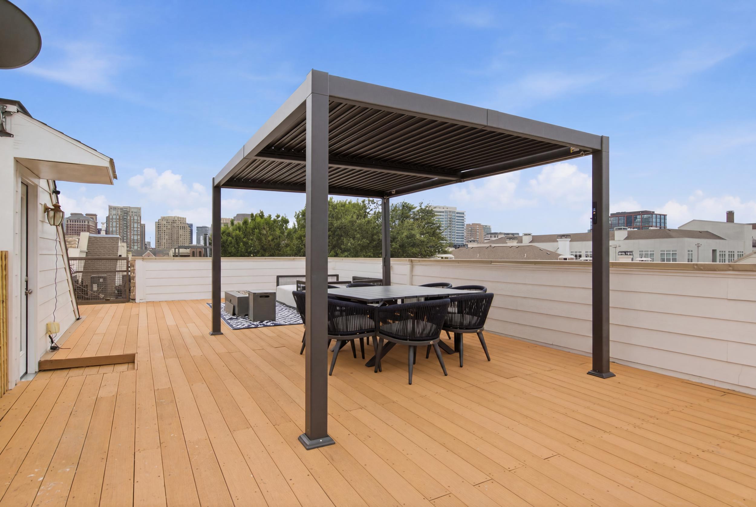 Unwind with stunning skyline views in this chic outdoor dining setup!