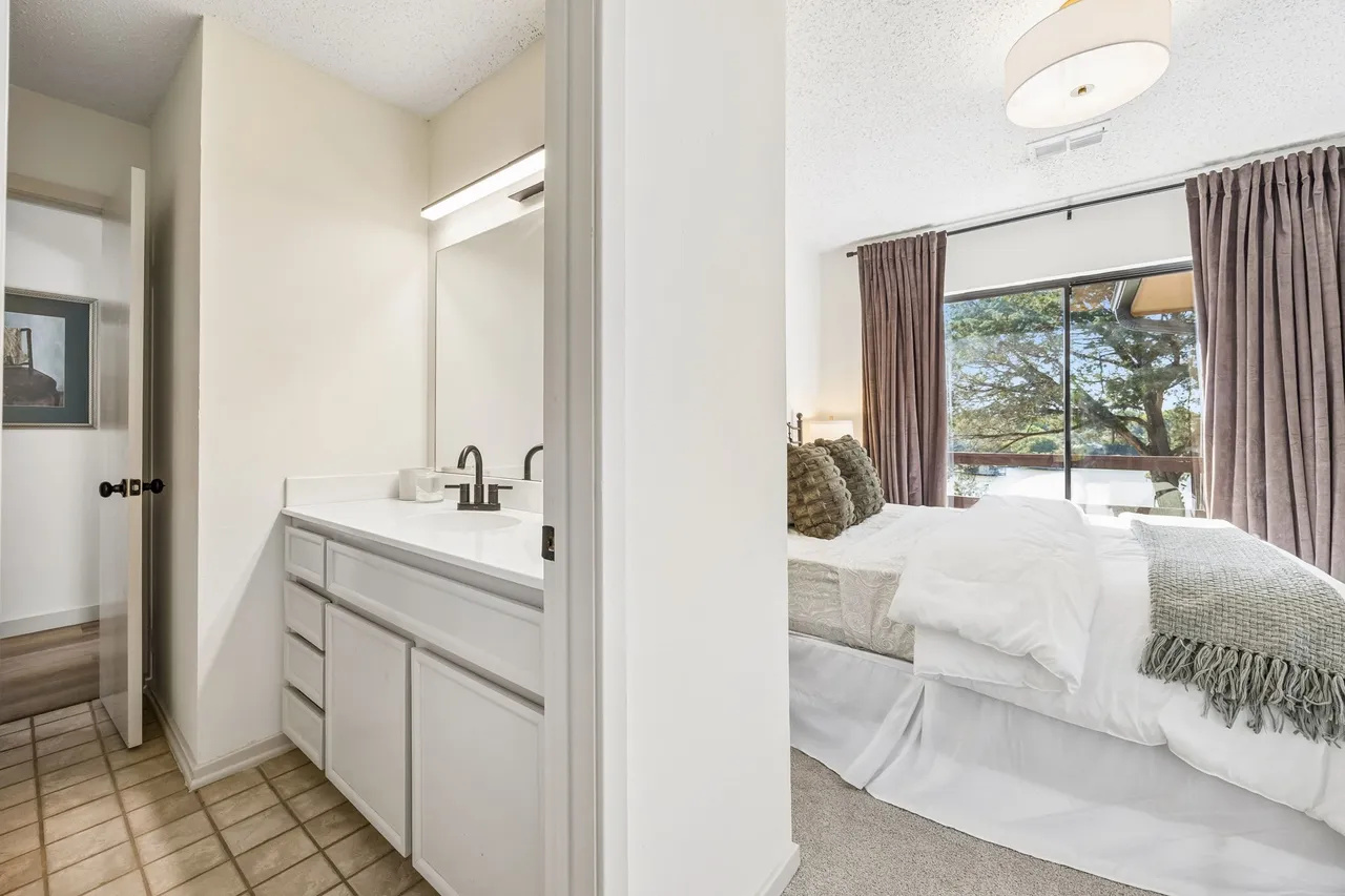 Bedroom access beside a full bathroom vanity.