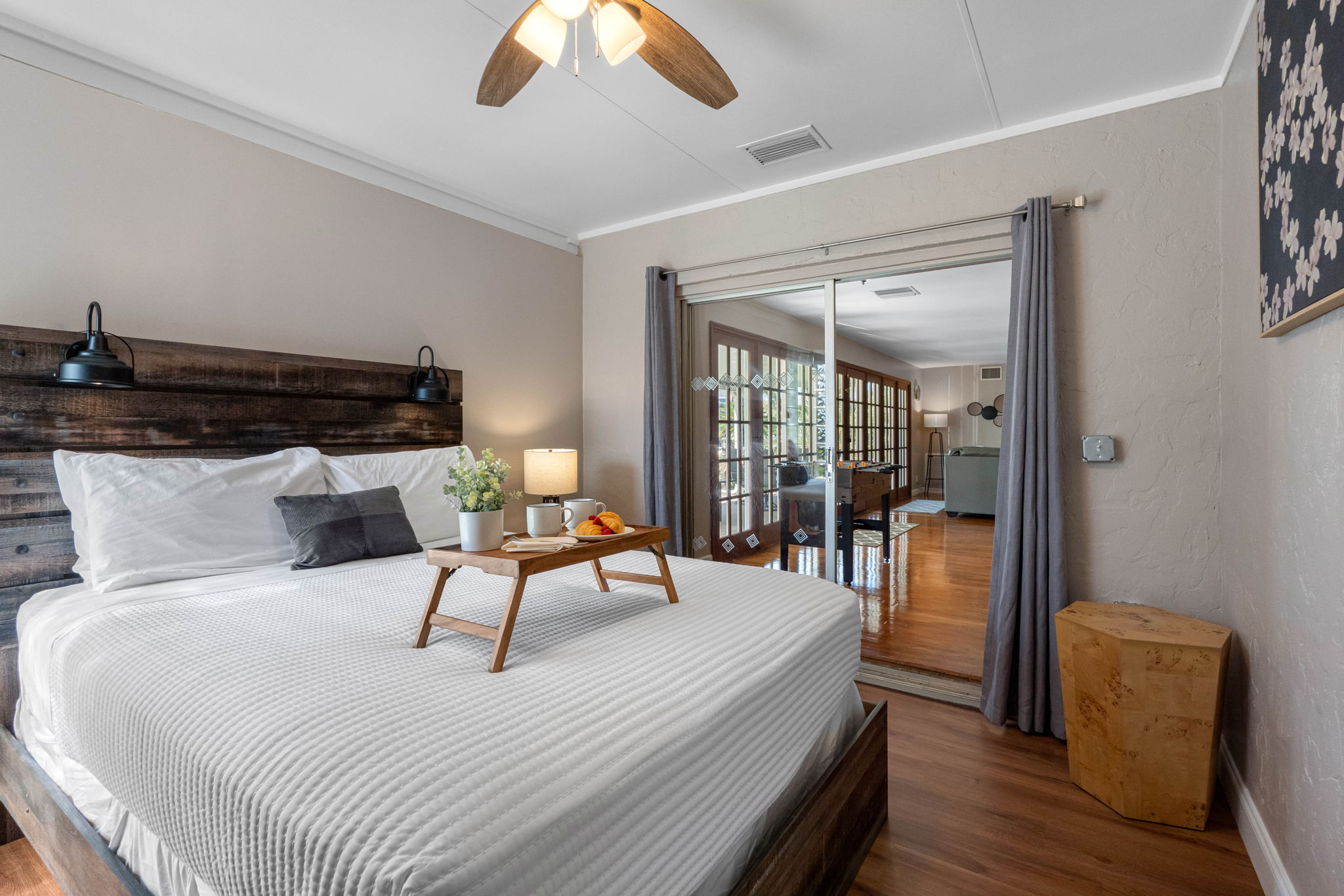 This bedroom offers a warm and inviting retreat with a rustic wood bed frame, soft lighting, and calming neutral tones.