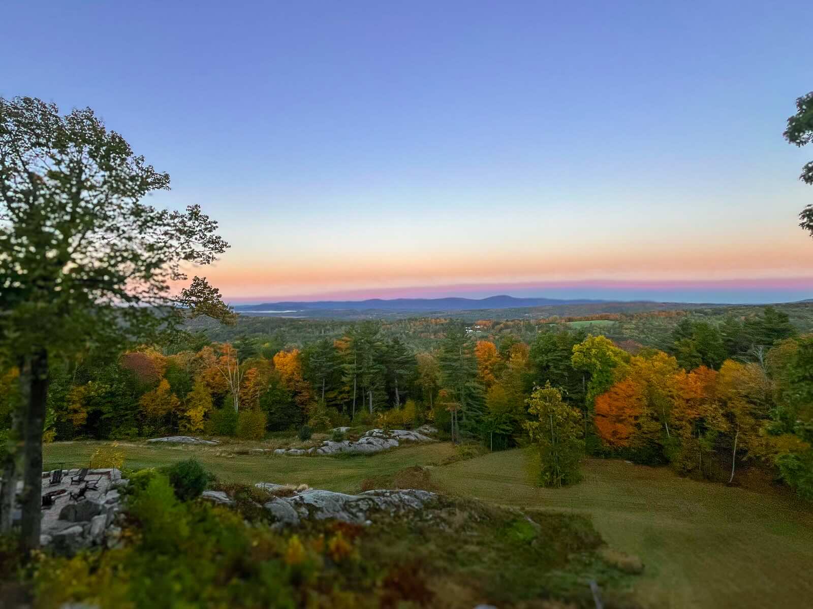 Fall foliage at dusk across the fields and stone outcrops to the Berkshires ridgeline &mdash; Sunset Falls Estate