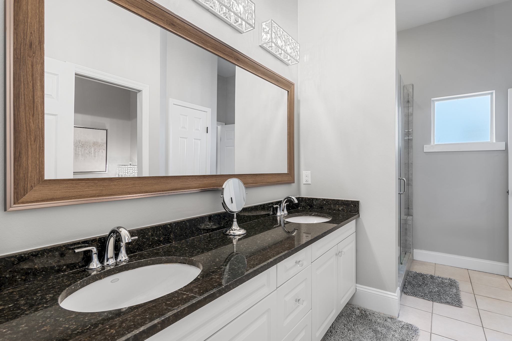 Master bathroom with granite double vanity and large mirror