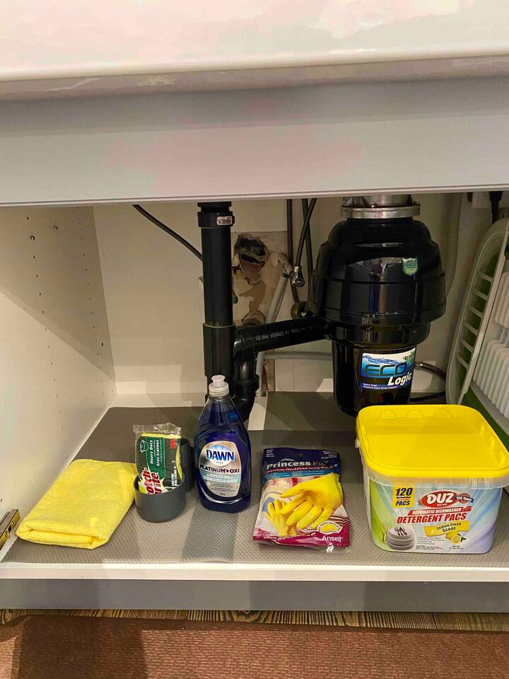 Under the kitchen sink are cleaning supplies.