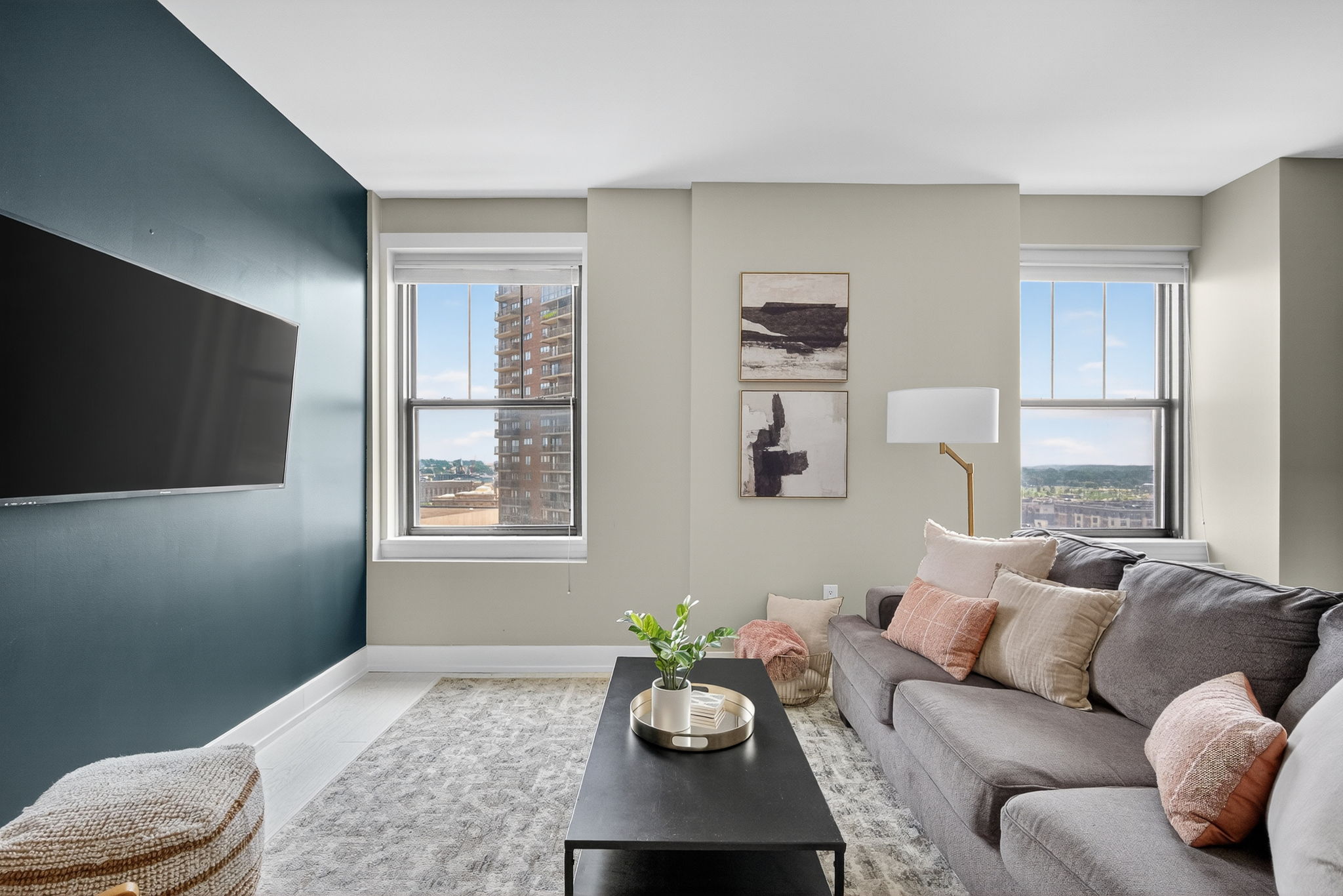 Relax in a stylish living room with a mounted flatscreen TV, curated decor, and a luxe accent wall.