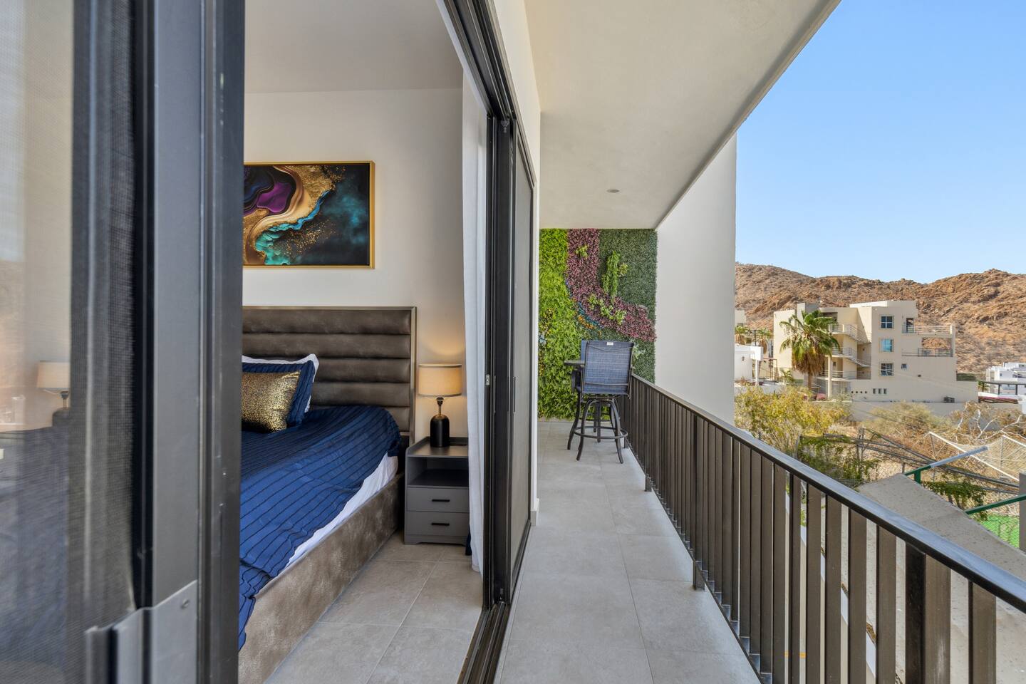 Enjoy stunning views from the master bed balcony, facing the lush outdoor nature wall with the majestic Pedregal mountain in the background.