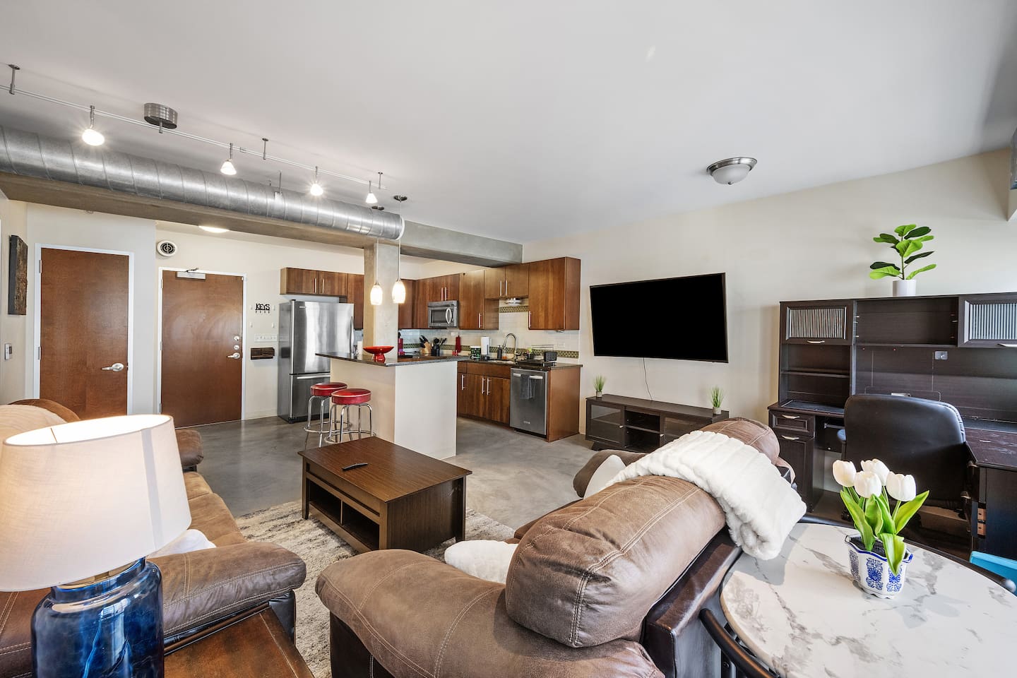 Spacious living room with 65" Curved TV.  Also a two person dining table behind the love seat.