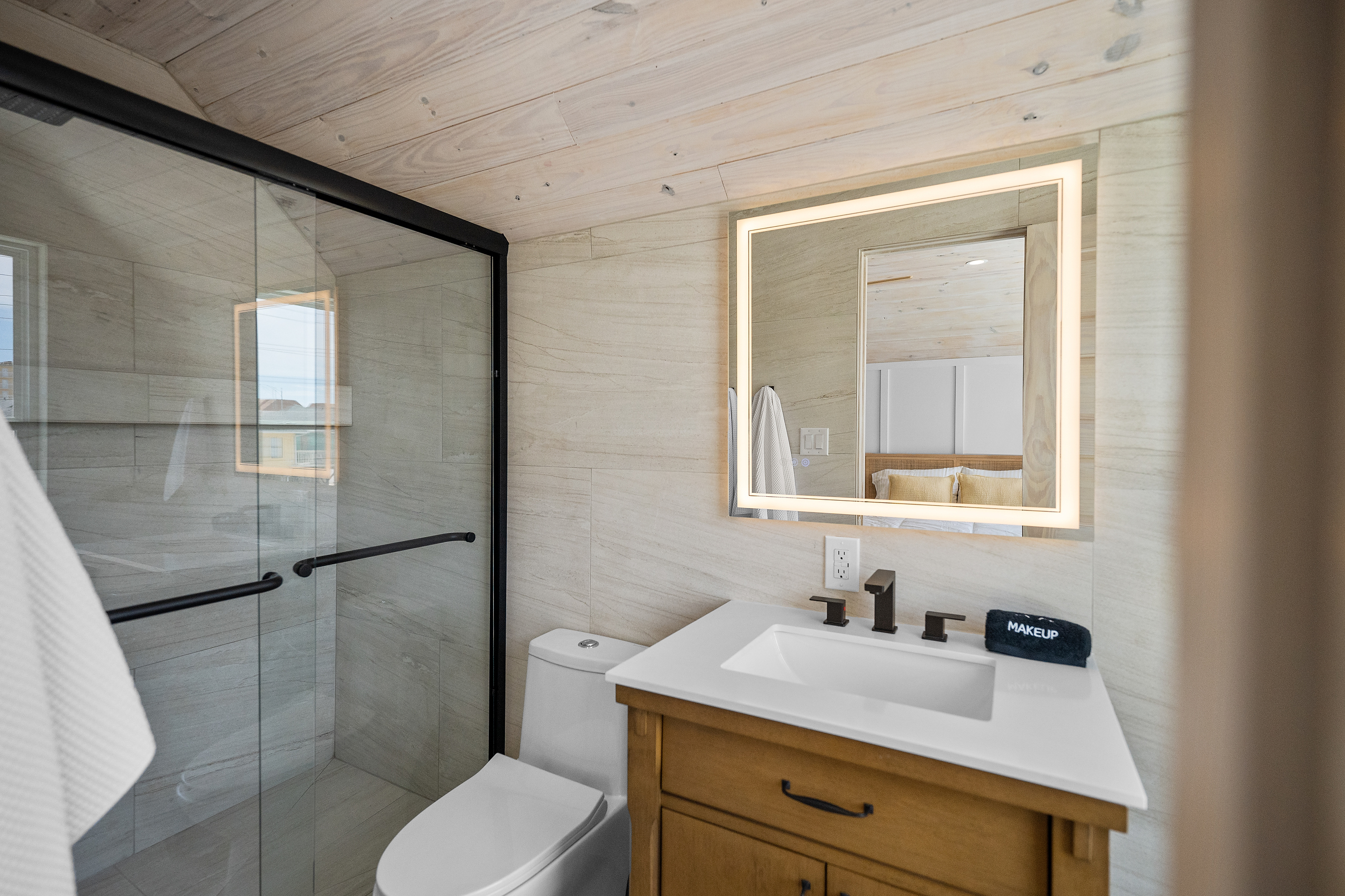Another bright full bathroom with a walk-in shower and modern finishes.