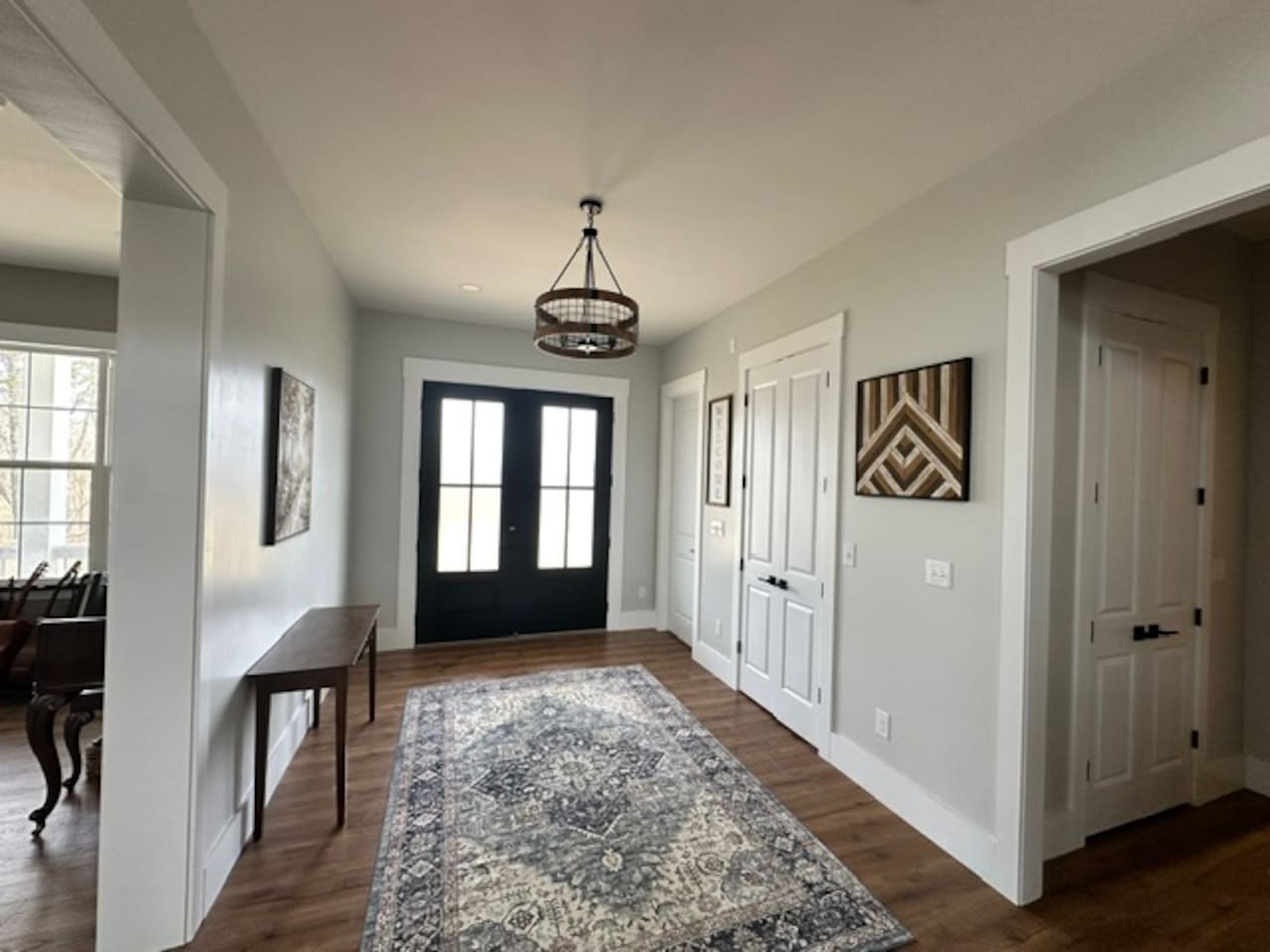 Our front doors open toward the grand staircase & open living room/kitchen area, with the library/music room on the right when you enter. The hallway on the opposite side leads to an extra full bath, laundry, & a second master bedroom door. 