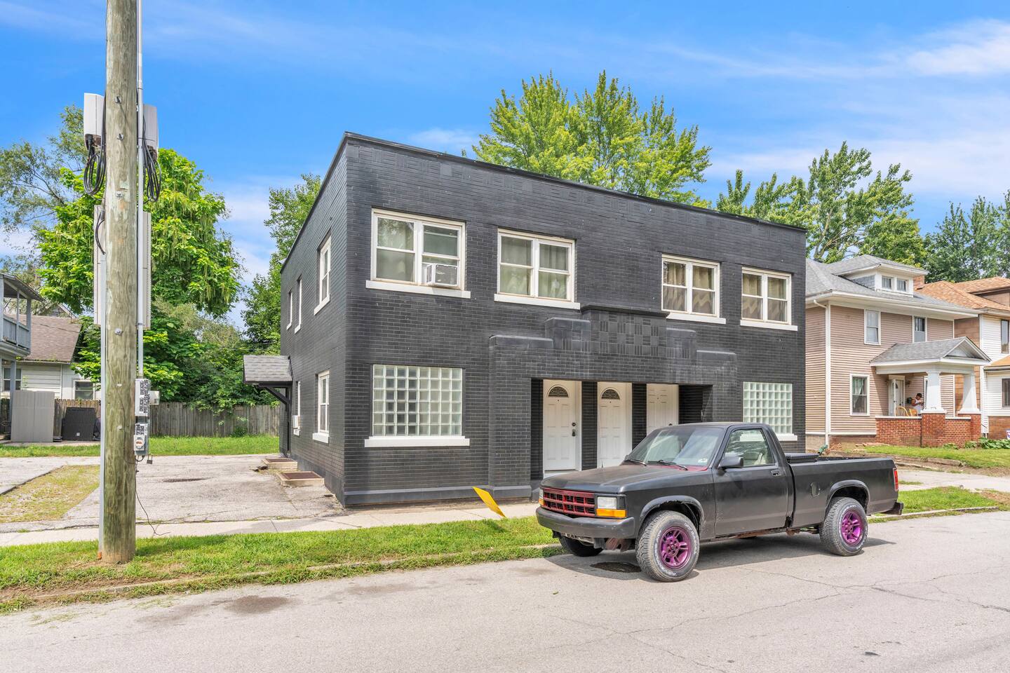 Stylish two-story building with sleek black brick façade and large windows, offering a contemporary urban vibe.