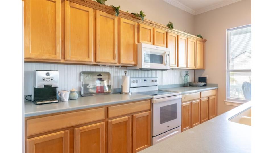 Fully equipped kitchen with everything you need for meal prep and family dinners. Features include full-size appliances, ample counter space, abundant cabinet storage, and a convenient breakfast bar with seating.