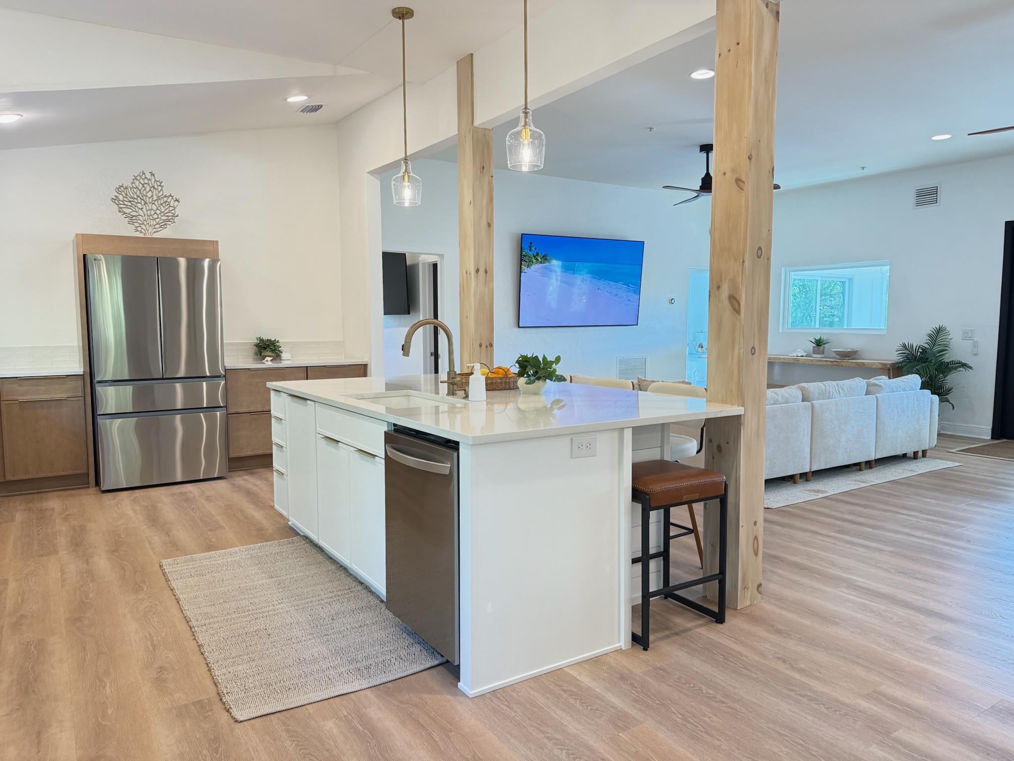 Open concept luxury living featuring one of two 85" smart TVs at the home